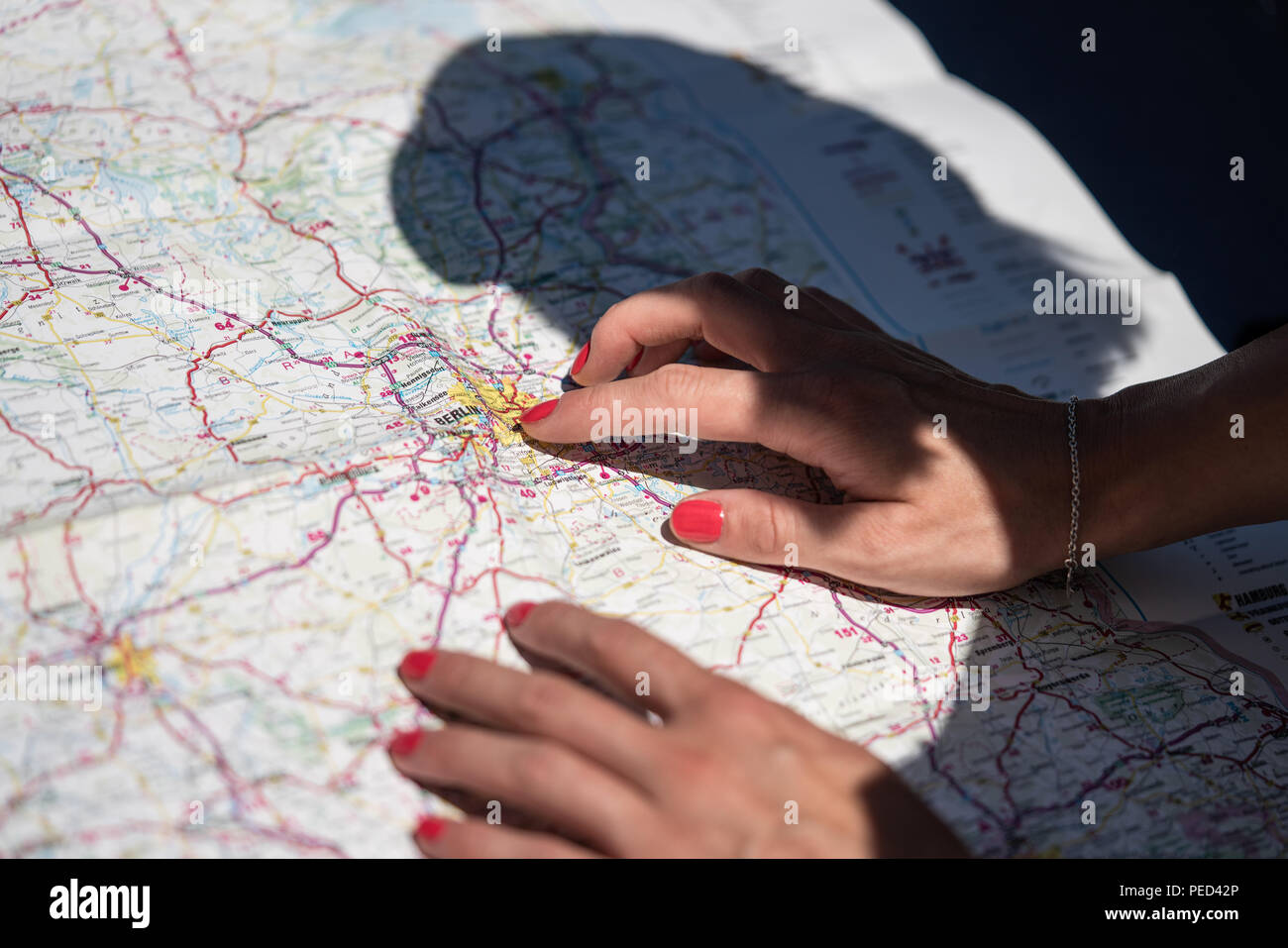 A woman is reading a road atlas in Germany. Stock Photo