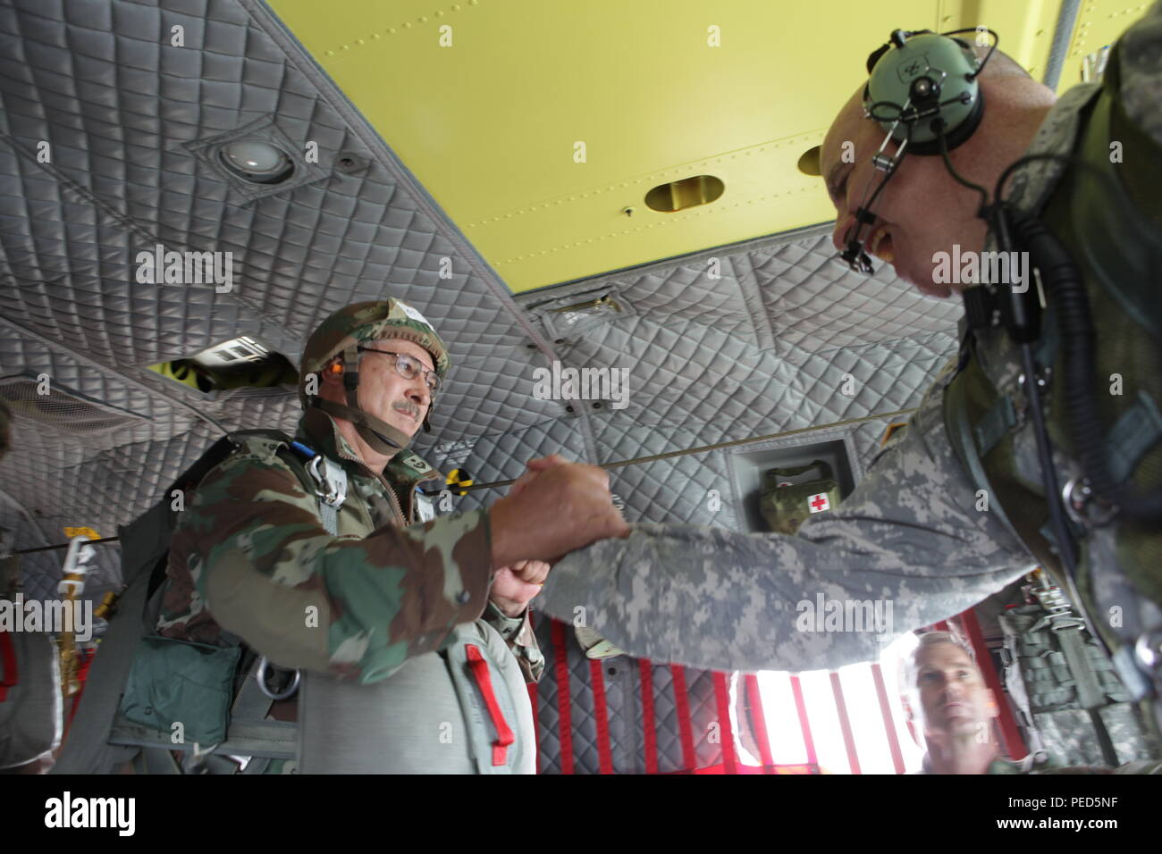 South African Lt. Col. Hrige Van Heerden from the 44th Para lets U.S. Army Master Sgt. Tommy O'Hare from the Special Operations Detachment Global, R.I. National Guard know that his equipment has been checked and he is ready to exit a U.S. Army CH-47 during Leapfest 2015, Aug.1, 2015. Leapfest is an International parachute competition hosted by the 56th Troop Command, Rhode Island National Guard to promote high level technical training and esprit de corps within the International Airborne community. (U.S. Army Photo by Sgt. 1st Class Horace Murray/ Released) Stock Photo