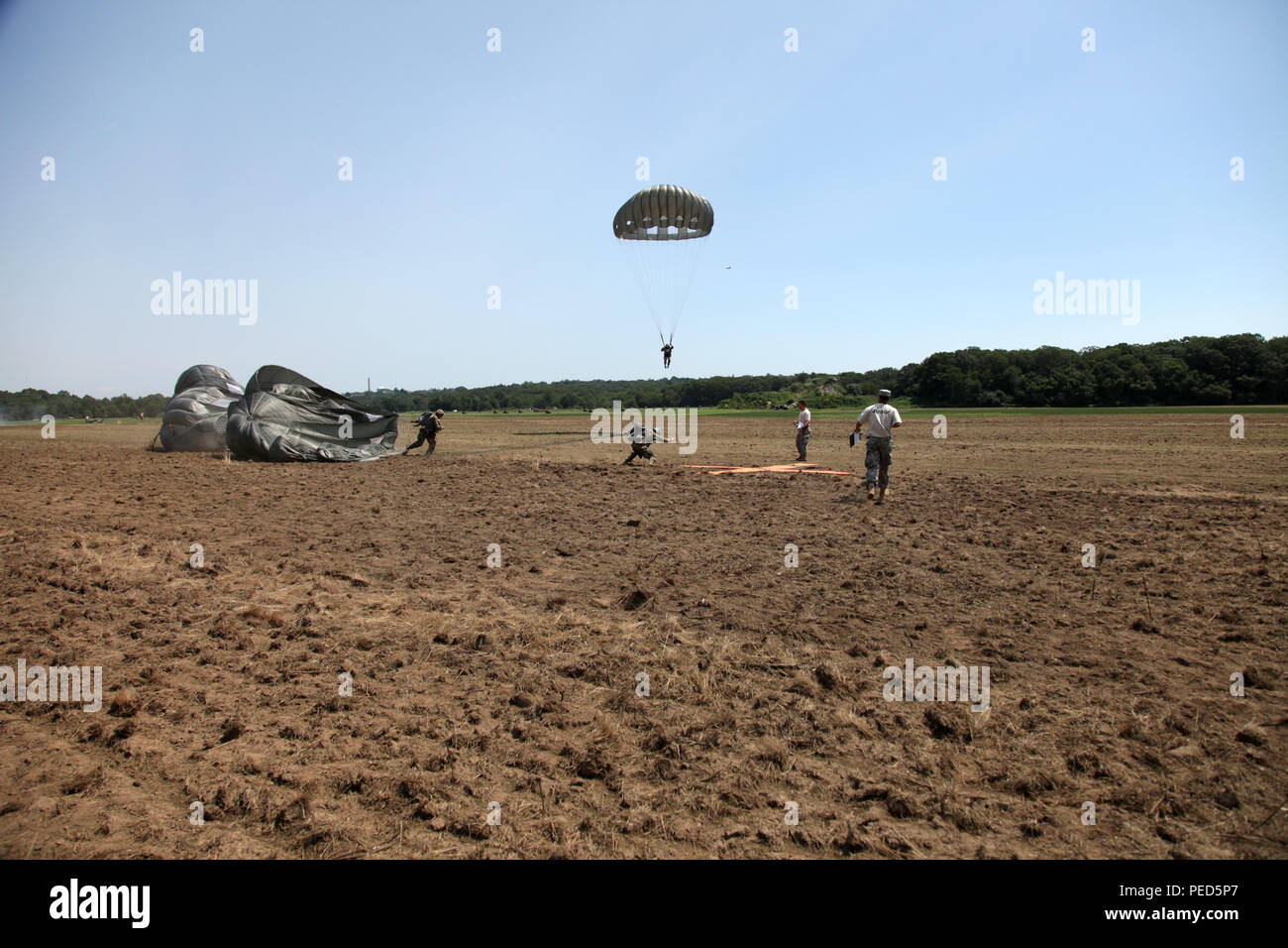 Paratroopers attempt to reach a target as quickly as possible on the drop zone at Leapfest in West Kingston, R.I., Aug. 1, 2015. Leapfest is an International parachute competition hosted by the 56th Troop Command, Rhode Island National Guard to promote high level technical training and esprit de corps within the International Airborne community. (U.S. Army Photo by Spc. Josephine Carlson/Released) Stock Photo