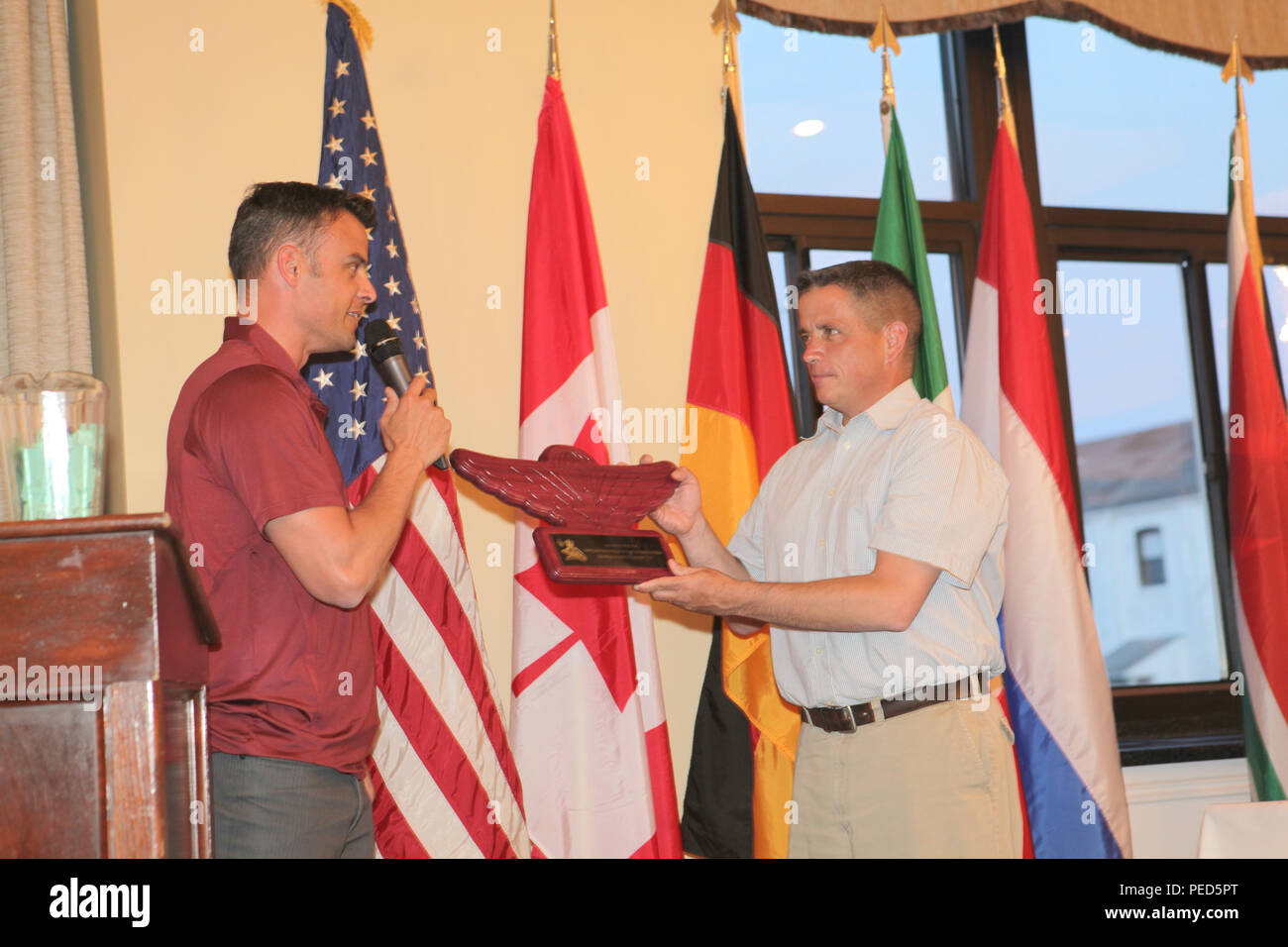 Canadian Capt. Noel Mark from the 3rd Battalion, Royal 22nd Regiment presents a gift of Canadian wings to U.S. Army Lt. Col. David Neary, Acting Brigade Commander of the 56th Troop Command, R.I. National Guard during the awards ceremony, Aug. 1, 2015. Leapfest is an International parachute competition hosted by the 56th Troop Command, Rhode Island National Guard to promote high level technical training and esprit de corps within the International Airborne community. (U.S. Army Photo by Sgt. 1st Class Horace Murray/ Released) Stock Photo