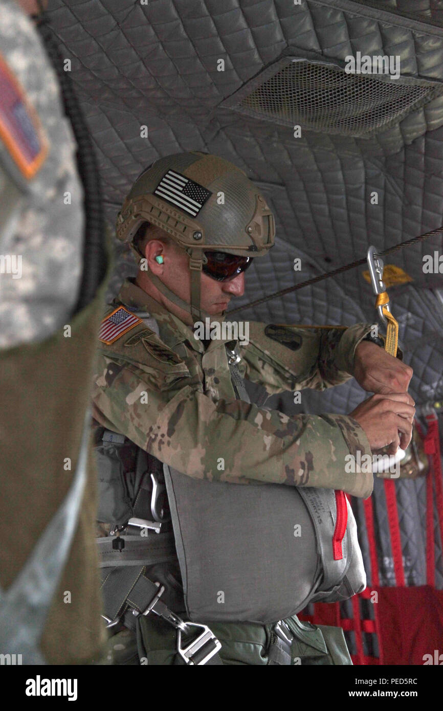 U.S. Army Staff Sgt. Justin Morelli, 982nd Combat Camera Co., checks the static line prior to a jump at Leapfest in West Kingston, R.I., Aug. 1, 2015. Leapfest is an International parachute competition hosted by the 56th Troop Command, Rhode Island National Guard to promote high level technical training and esprit de corps within the International Airborne community. (U.S. Army Photo by Spc. Josephine Carlson/Released) Stock Photo