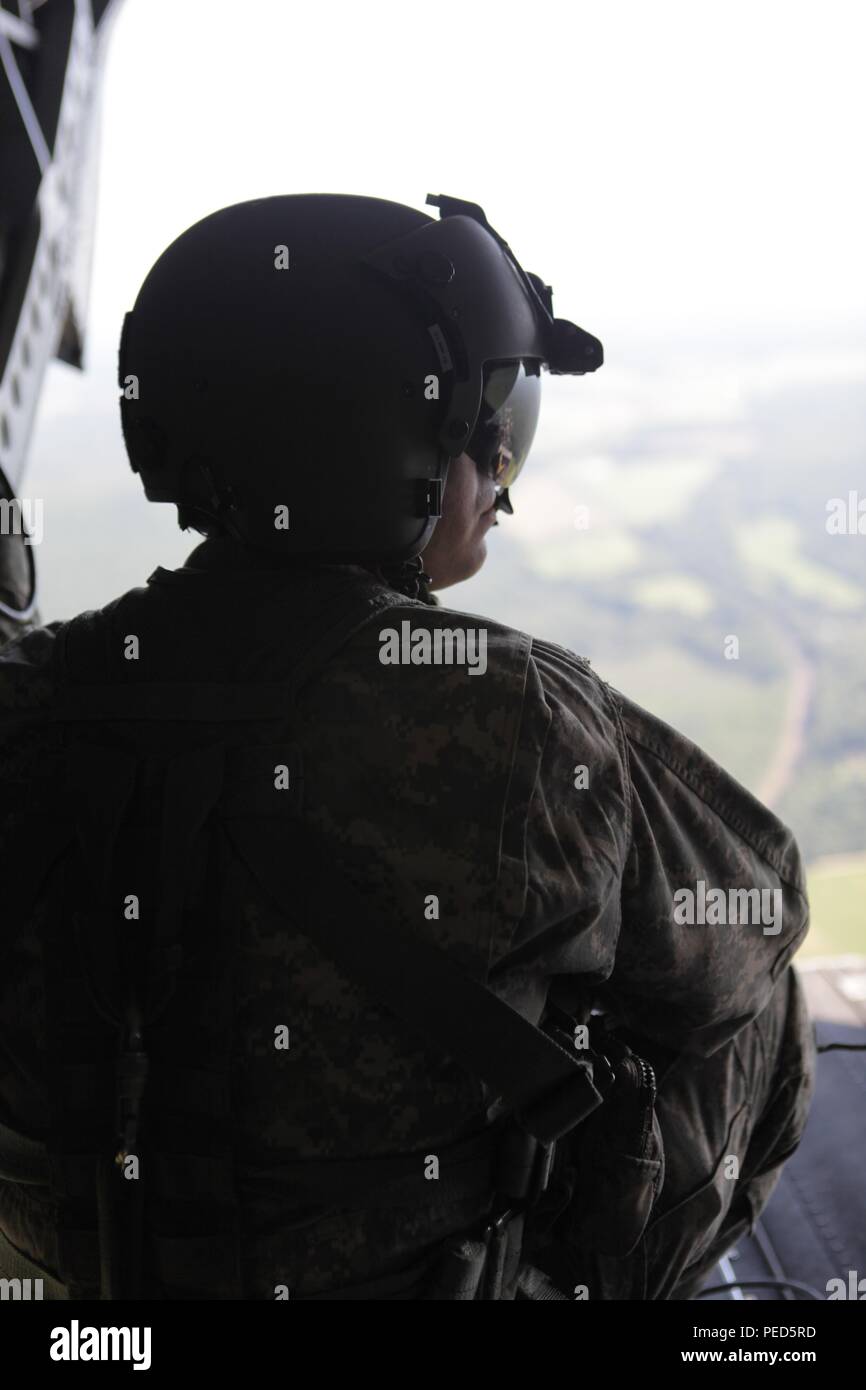 U.S. Army Staff Sgt. Brian Tenace from the 3rd Batallion, 126 Aviation Regiment monitors the ground below from his CH-47 helicopter during Leapfest 2015, Aug. 1, 2015. Leapfest is an International parachute competition hosted by the 56th Troop Command, Rhode Island National Guard to promote high level technical training and esprit de corps within the International Airborne community. (U.S. Army Photo by Sgt. 1st Class Horace Murray/ Released) Stock Photo