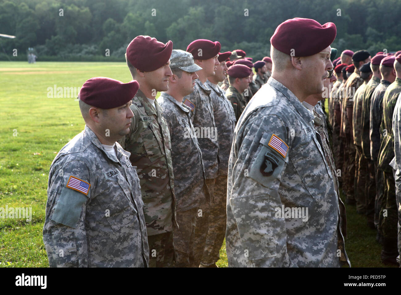 U.S. Army Staff Sgts. Edward Reagan and Justin Morelli of the 982nd Combat Camera Company (Airborne) stand in formation during the opening ceremonies of Leapfest 2015 in West Kingston, R.I., Aug. 1, 2015. Leapfest is an International parachute competition hosted by the 56th Troop Command, Rhode Island National Guard to promote high level technical training and esprit de corps within the International Airborne community. (U.S. Army Photo by Spc. Joseph Cathey/Released) Stock Photo