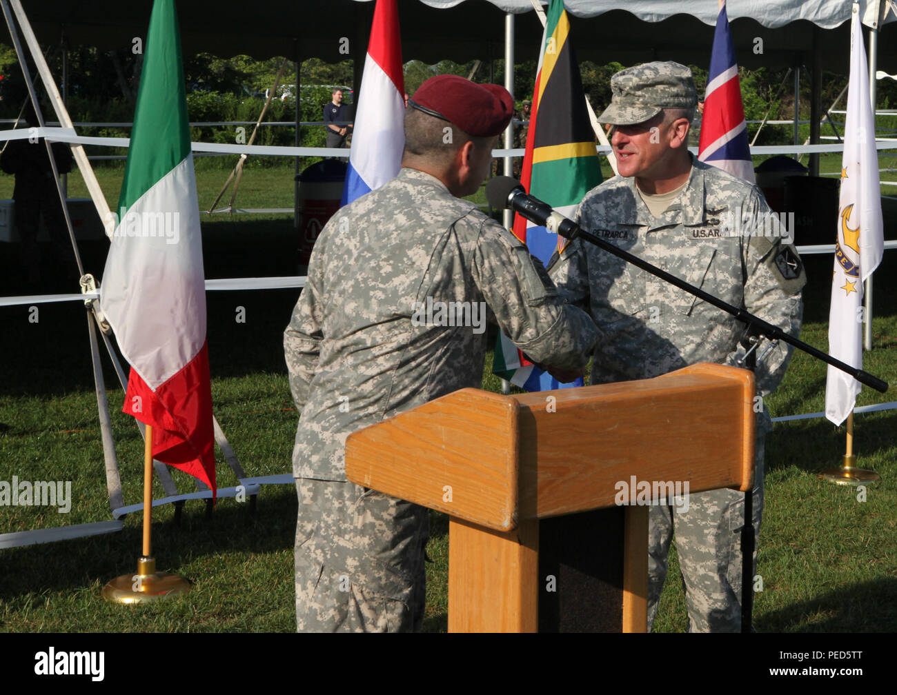 U.S. Army Brig. Gen. Charles Petrarcha, Rhode Island National Guard land forces component commander, receives the Leapfest coin from Lt. Col. David Neary, acting brigade commander of the 56th troop command, during Leapfest 2015 in West Kingston, R.I., Aug. 1, 2015. Leapfest is an International parachute competition hosted by the 56th Troop Command, Rhode Island National Guard to promote high level technical training and esprit de corps within the International Airborne community. (U.S. Army Photo by Spc. Joseph Cathey/Released) Stock Photo
