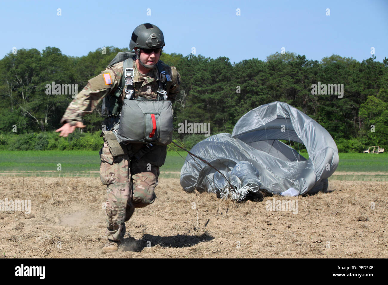 A U.S. Army paratrooper runs to the 'X' on the drop zone during Leapfest in West Kingston, R.I., Aug. 1, 2015. Leapfest is an International parachute competition hosted by the 56th Troop Command, Rhode Island National Guard to promote high level technical training and esprit de corps within the International Airborne community. (U.S. Army Photo by Spc. Joseph Cathey/Released) Stock Photo