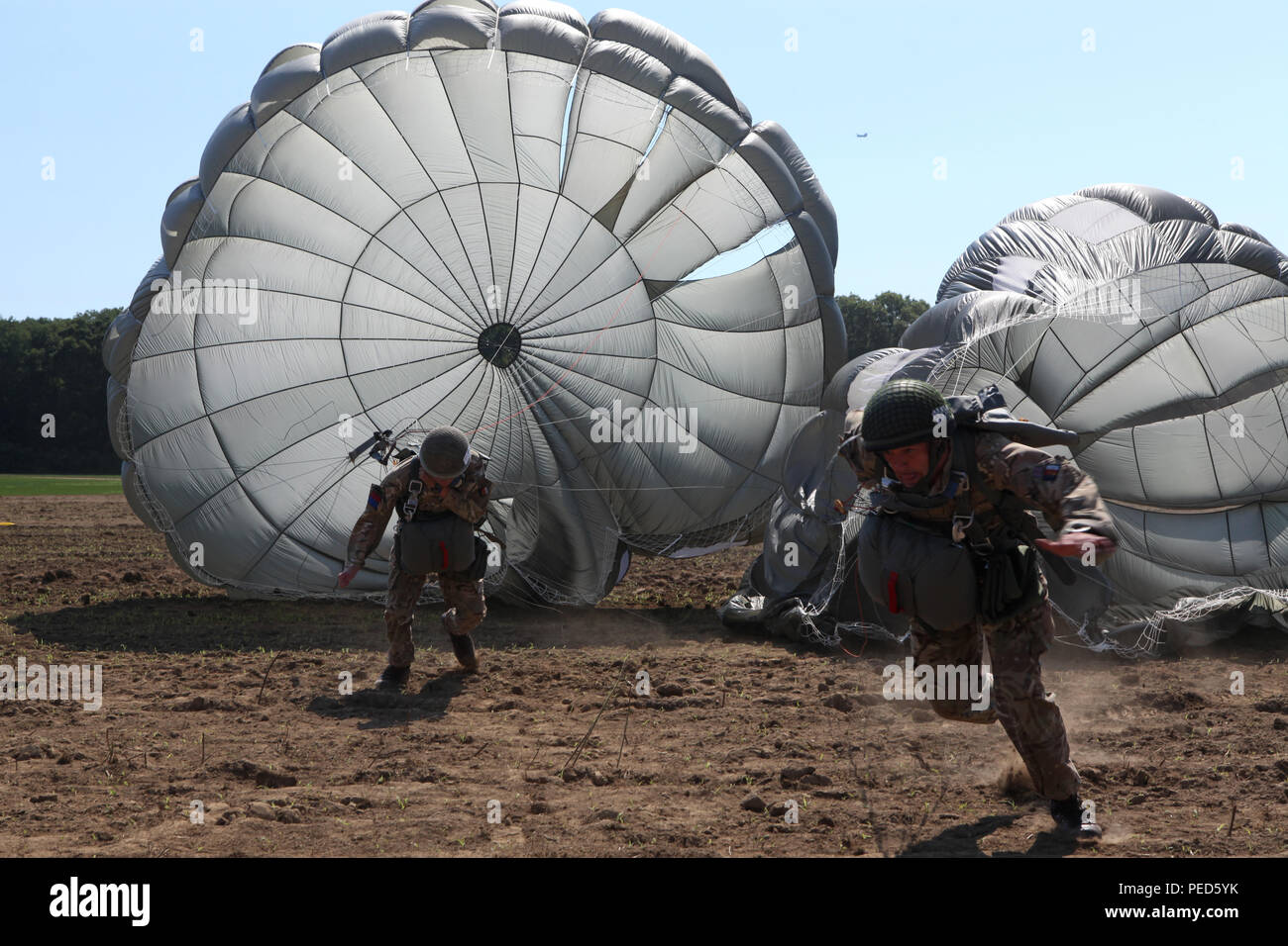 British paratroopers run toward the 'X' on the drop zone during Leapfest 2015 in West Kingston, R.I., Aug. 1, 2015. Leapfest is an International parachute competition hosted by the 56th Troop Command, Rhode Island National Guard to promote high level technical training and esprit de corps within the International Airborne community. (U.S. Army Photo by Spc. Joseph Cathey/Released) Stock Photo