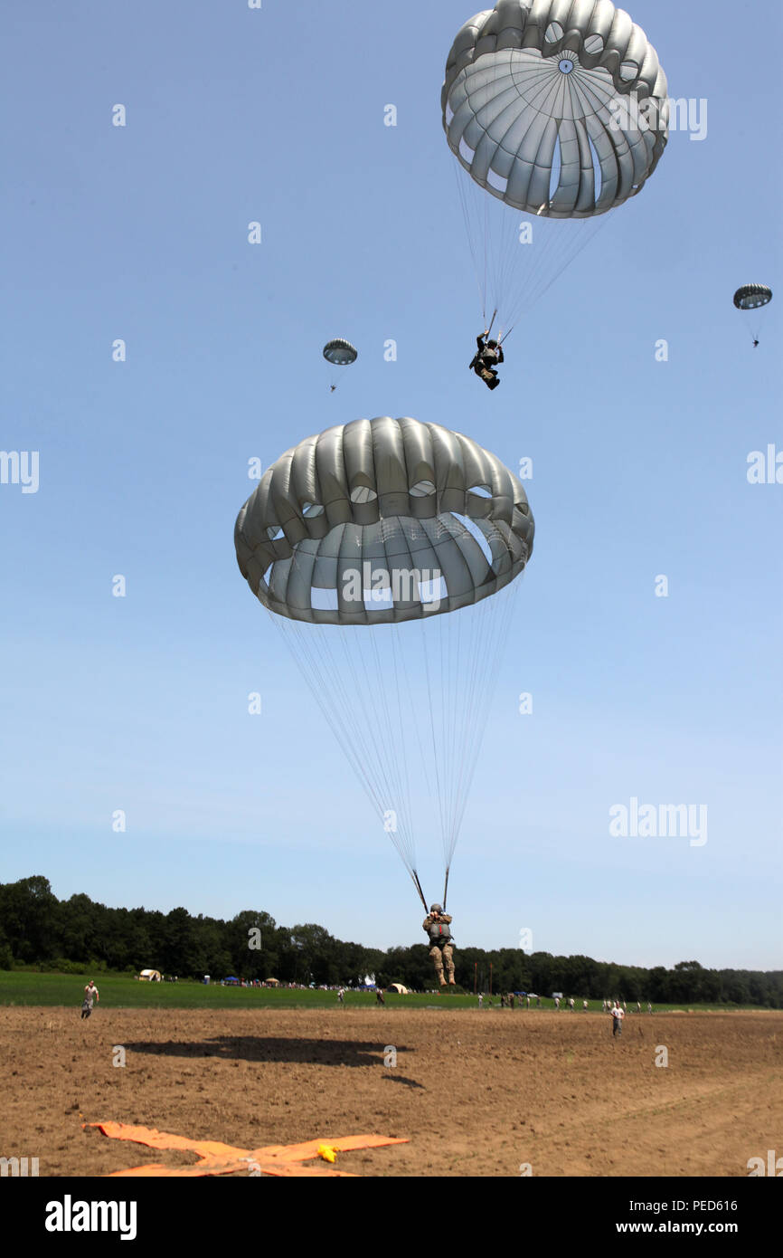 U.S. Army paratroopers from the 982d Combat Camera Company (Airborne) prepare to land on the drop zone as part of a multi lateral parachute team during Leapfest 2015 in West Kingston, R.I., Aug. 1, 2015. Leapfest is an International parachute competition hosted by the 56th Troop Command, Rhode Island National Guard to promote high level technical training and esprit de corps within the International Airborne community. (U.S. Army Photo by Spc. Joseph Cathey/ Released) Stock Photo