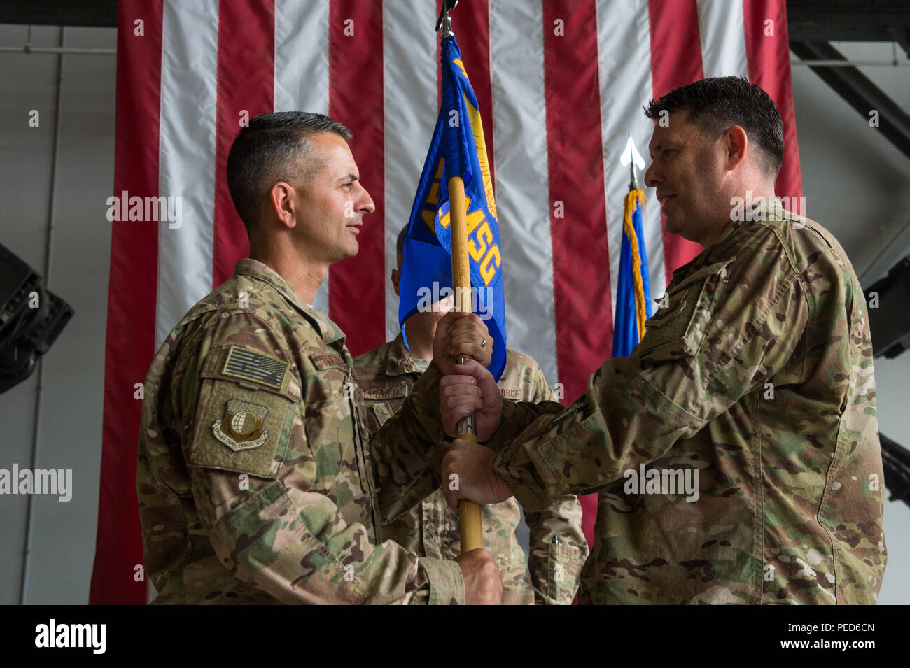U.S. Air Force Brig. Gen. Dave Julazadeh, 455th Air Expeditionary Wing commander, hands the guidon to Col. William Clark, 455th Expeditionary Mission Support Group incoming commander, during the 455th EMSG change of command ceremony at Bagram Air Field, Afghanistan, Aug. 3, 2015. The 455th MSG is comprised of five squadrons responsible for communications, civil engineer operations, force support, logistics readiness, and security forces. (U.S. Air Force photo by Tech. Sgt. Joseph Swafford/Released) Stock Photo