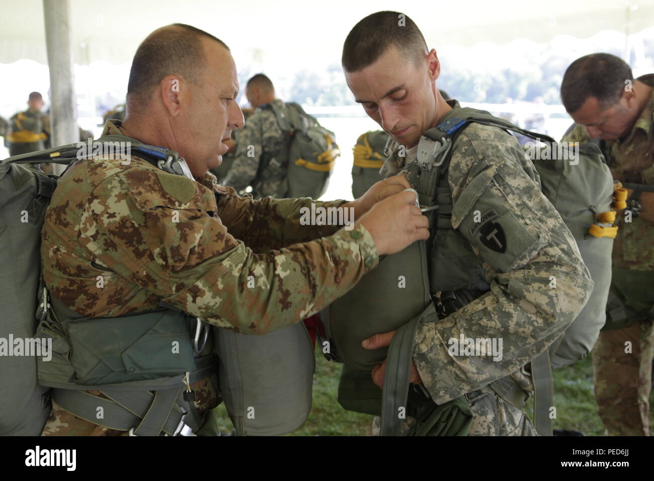 Italian 1st Lt. Antonio Nucera aids U.S. Army Staff Sgt. Paul Norwood from B Company, 1st Battalion, 143rd Infantry Regiment, Alaska National Guard, check the attachment of his reserve parachute for the wing exchange jump, Aug. 3, 2015. Leapfest is an International parachute competition hosted by the 56th Troop Command, Rhode Island National Guard to promote high level technical training and esprit de corps within the International Airborne community. (U.S. Army Photo by Sgt. 1st Class Horace Murray/Released) Stock Photo