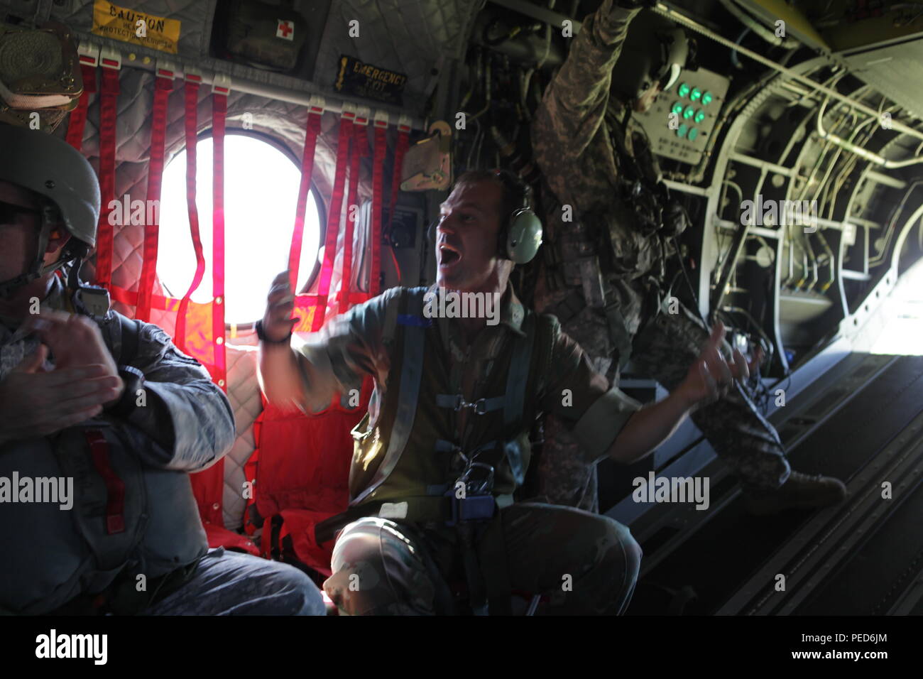South African Lt. Col. Laurel Thatcher sings a traditional paratrooper song with his paratroopers before sending them out of a U.S. Army CH-47 Chinook during the international wing exchange jump, Aug. 3, 2015.  Leapfest is an International parachute competition hosted by the 56th Troop Command, Rhode Island National Guard to promote high level technical training and esprit de corps within the International Airborne community. (U.S. Army Photo by Sgt. 1st Class Horace Murray/Released) Stock Photo