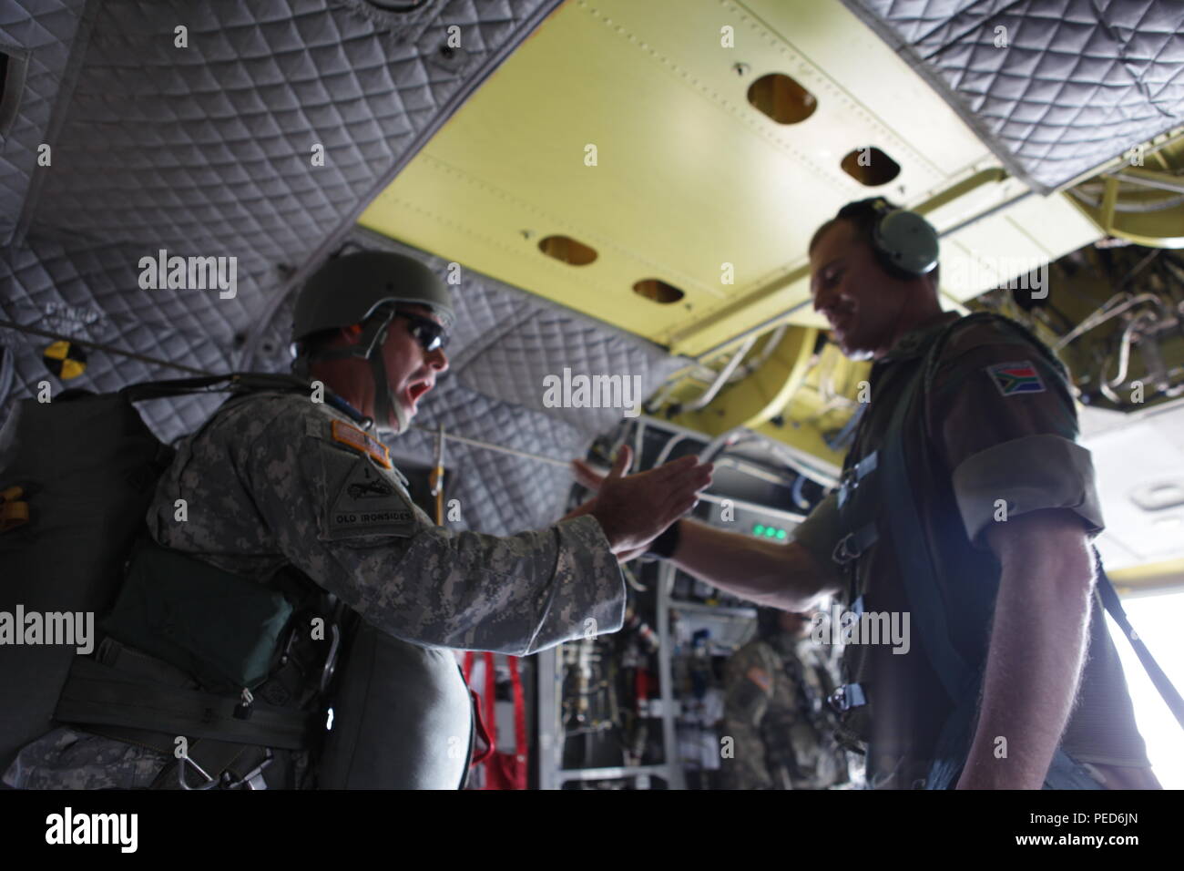 South African Lt. Col. Laurel Thatcher receives the signal from the first jumper that everything is 'All OK' before sending them out of a U.S. Army CH-47 Chinook during the international wing exchange jump, Aug. 3, 2015.  Leapfest is an International parachute competition hosted by the 56th Troop Command, Rhode Island National Guard to promote high level technical training and esprit de corps within the International Airborne community. (U.S. Army Photo by Sgt. 1st Class Horace Murray/Released) Stock Photo