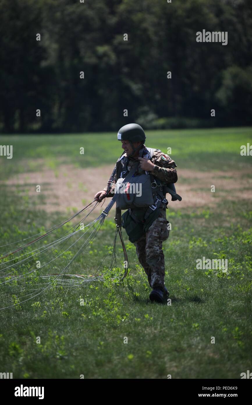 An Italian paratrooper prepares to remove is his MC-6 parachute harness after landing at West Kingston, R.I. during a wing exchange jump, Aug. 3, 2015.  Leapfest is an International parachute competition hosted by the 56th Troop Command, Rhode Island National Guard to promote high level technical training and esprit de corps within the International Airborne community. (U.S. Army Photo by Sgt. 1st Class Horace Murray/Released) Stock Photo