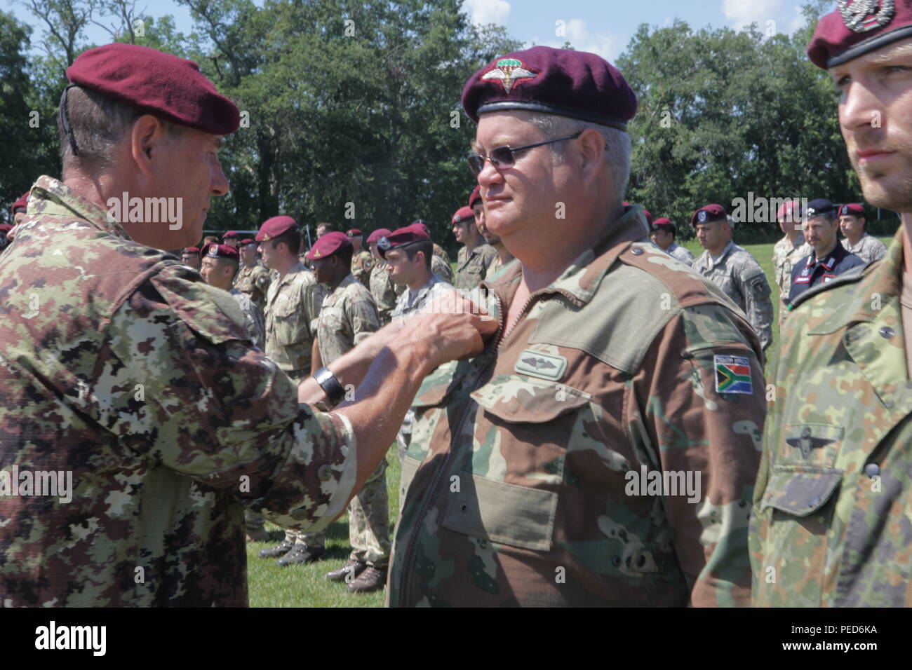 An Italian Jumpmaster pins Italian wings on a South African paratrooper during the wing exchange ceremony for completing a jump with an Italian jumpmaster, Aug. 3, 2015.  Leapfest is an International parachute competition hosted by the 56th Troop Command, Rhode Island National Guard to promote high level technical training and esprit de corps within the International Airborne community. (U.S. Army Photo by Sgt. 1st Class Horace Murray/Released) Stock Photo