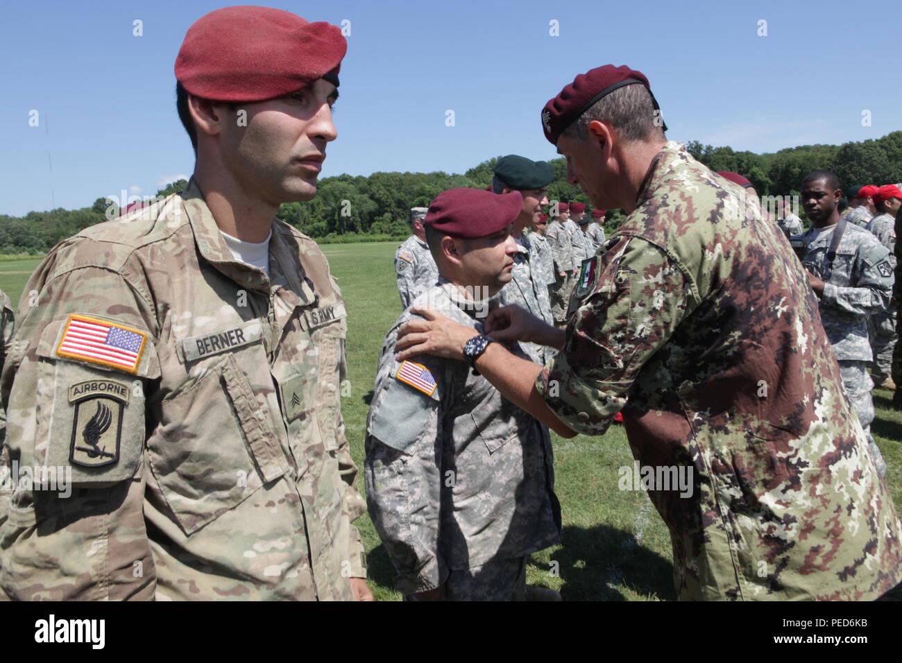 An Italian Jumpmaster pins Italian wings on U.S. Army Staff Sgt. Edward Reagan, from the 982nd Combat Camera Company (Airborne), during the wing exchange ceremony for completing a jump with an Italian jumpmaster, Aug. 3, 2015.  Leapfest is an International parachute competition hosted by the 56th Troop Command, Rhode Island National Guard to promote high level technical training and esprit de corps within the International Airborne community. (U.S. Army Photo by Sgt. 1st Class Horace Murray/Released) Stock Photo