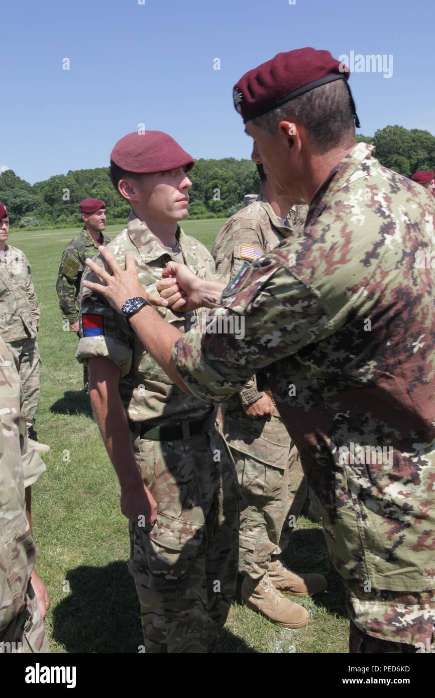 An Italian Jumpmaster pins Italian wings on United Kingdom paratrooper GNR Shaun Knight from the 7th PARA, Royal Horse Artillery, during the wing exchange ceremony for completing a jump with an Italian jumpmaster, Aug. 3, 2015.  Leapfest is an International parachute competition hosted by the 56th Troop Command, Rhode Island National Guard to promote high level technical training and esprit de corps within the International Airborne community. (U.S. Army Photo by Sgt. 1st Class Horace Murray/Released) Stock Photo