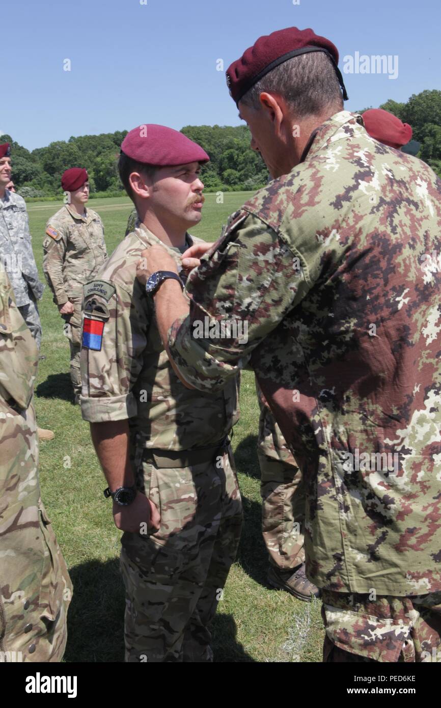 An Italian Jumpmaster pins Italian wings on United Kingdom paratrooper Sgt. Owen Jones from the 7th PARA, Royal Horse Artillery, during the wing exchange ceremony for completing a jump with an Italian jumpmaster, Aug. 3, 2015.  Leapfest is an International parachute competition hosted by the 56th Troop Command, Rhode Island National Guard to promote high level technical training and esprit de corps within the International Airborne community. (U.S. Army Photo by Sgt. 1st Class Horace Murray/Released) Stock Photo