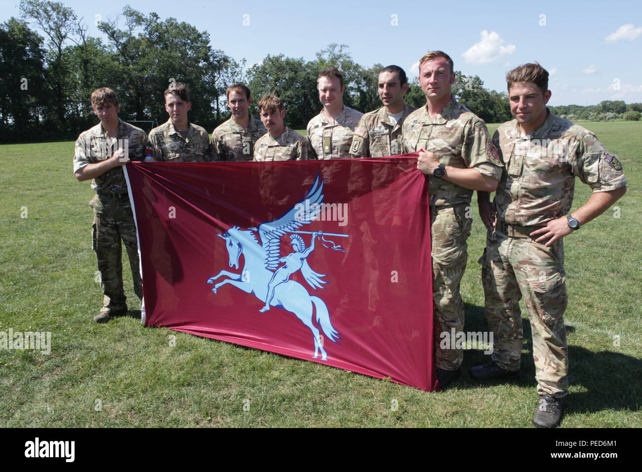 Paratroopers from the 7th PARA, Royal Horse Artillery along with U.S. Army Sgt. Austin Burner display their unit flag at the closing of Leapfest in West Kingston, R.I., Aug. 3, 2015.  Leapfest is an International parachute competition hosted by the 56th Troop Command, Rhode Island National Guard to promote high level technical training and esprit de corps within the International Airborne community. (U.S. Army Photo by Sgt. 1st Class Horace Murray/Released) Stock Photo
