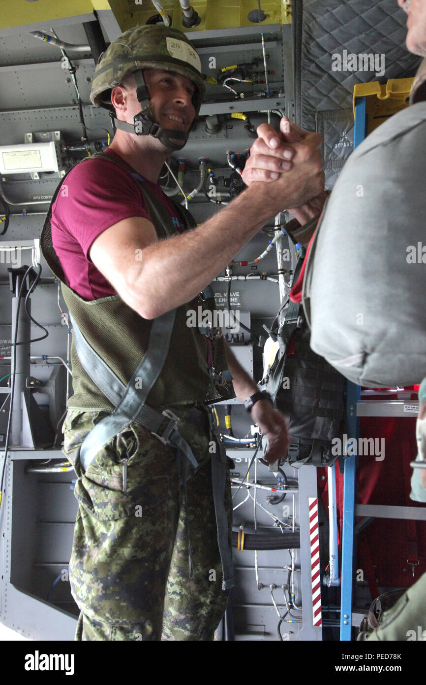 Canadian jumpmaster Sylvain Gagnon clasps hands with South African Col. Adrian Schoeman, the first jumper on his pass during the wing exchange, letting him know that his equipment has been checked and he is ready to jump,  West Kingston, R.I., Aug. 3, 2015. Leapfest is an International parachute competition hosted by the 56th Troop Command, Rhode Island National Guard to promote high level technical training and esprit de corps within the International Airborne community. (U.S. Army Photo by Spc. Josephine Carlson/Released) Stock Photo