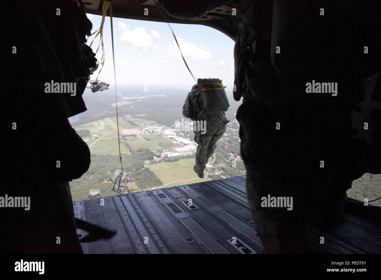A U.S. Army paratrooper jumps from a CH-47 Chinook helicopter at Leapfest during the wing exchange jump in West Kingston, R.I., Aug. 3, 2015. Leapfest is an International parachute competition hosted by the 56th Troop Command, Rhode Island National Guard to promote high level technical training and esprit de corps within the International Airborne community. (U.S. Army Photo by Spc. Josephine Carlson/Released) Stock Photo