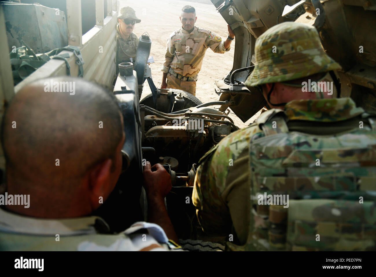 Australian soldiers assigned to Task Group Taji perform a vehicle inspection at Camp Taji, Iraq, Aug. 2, 2015. Through advise and assist and building partner capacity missions, the Combined Joint Task Force – Operation Inherent Resolve’s multinational coalition has trained more than 11,000 Iraqi security force personnel to defeat the Islamic State of Iraq and the Levant. A coalition of nations have joined together to enable Iraqi forces to counter ISIL, reestablish Iraq’s borders and retake lost terrain thereby restoring regional stability and security. (U.S. Army photo by Spc. William Marlow/ Stock Photo