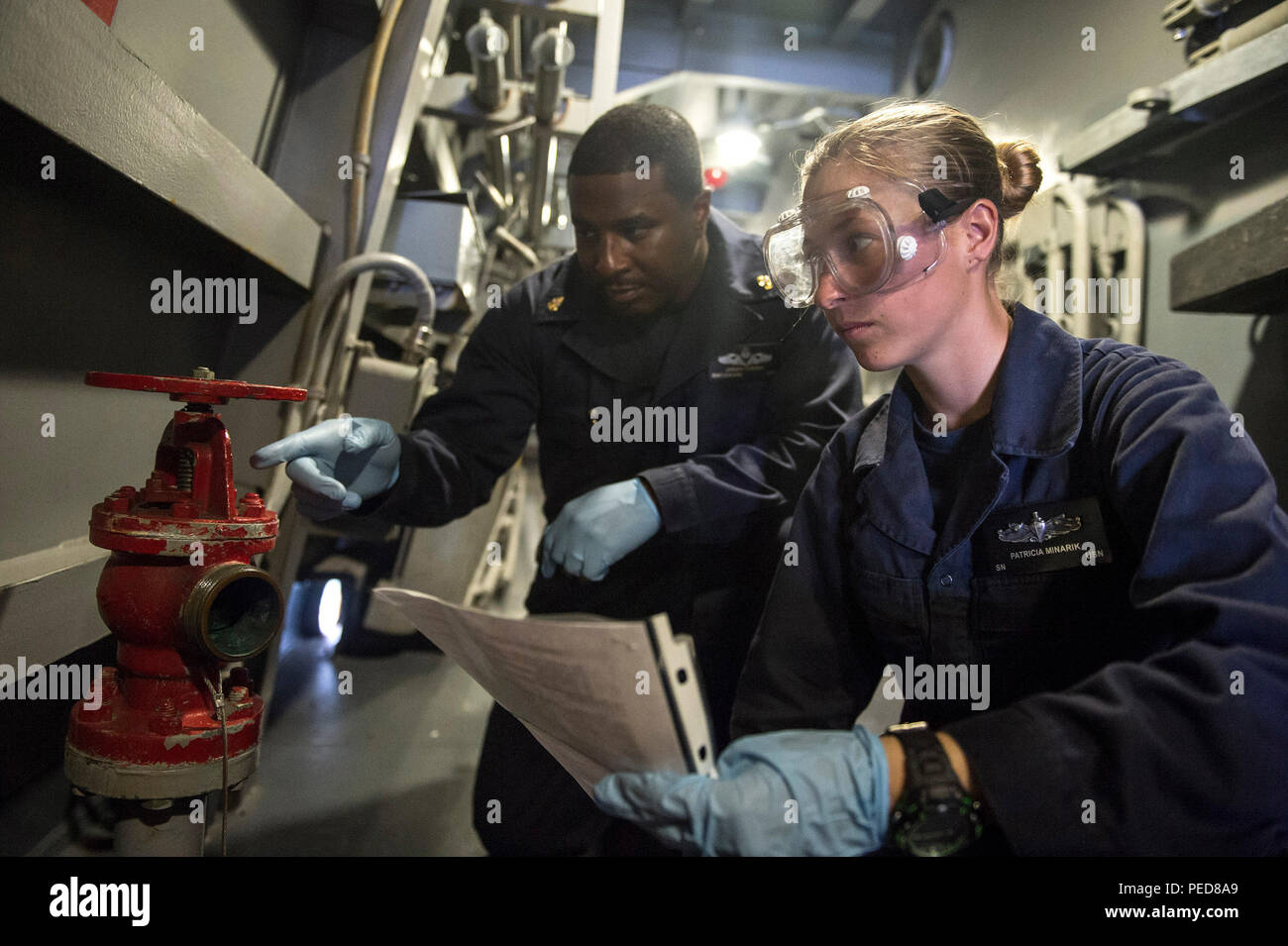 150804-N-UN259-208 WATERS SOUTH OF INDONESIA (Aug. 4, 2015) Chief Boatswains Mate Jabri Turner (left), from New Orleans, La., guides Boatswains Mate Seaman Patricia Minarik, from Twentynine Palms, Calif., on the procedures of valve maintenance on board the Arleigh Burke-class guided-missile destroyer USS Preble (DDG 88). Preble is deployed to the 7th Fleet area of responsibility in support of security and stability in the Indo-Asia-Pacific region. (U.S. Navy photo by Mass Communication Specialist 3rd Class Alonzo M. Archer/Released) Stock Photo