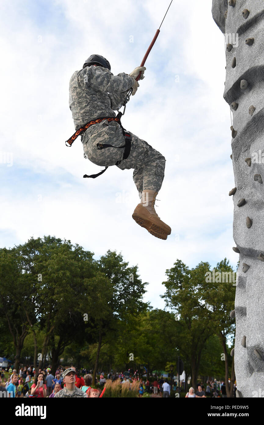 Sgt. 1st Class David Fittanto, 85th Support Command, rappels from the Chicago Recruiting Battalion’s rock climbing wall during the Arlington Heights Police Department’s National Night Out (NNO) community event, Aug. 4. The annual community event, which connects the local community with law enforcement and first responders, brought in an estimated 4000 in attendance. Soldiers also from the 327th Military Police Battalion participated, simultaneously, in another NNO at the Village of Rolling Meadows.  (U.S. Army photo by Sgt. Aaron Berogan/Released) Stock Photo