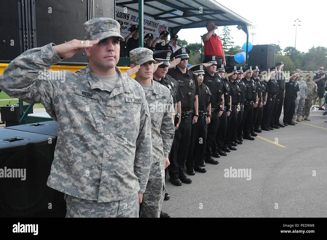 Second Lt. Michael Webb, left, physical security officer-in-charge for the 85th Support Command, renders a salute with police officers from the Rolling Meadows Police Department during the singing of the national anthem by Jim Cornelison, Chicago Blackhawks national anthem singer, at the Rolling Meadows Police National Night Out, Aug. 4.  Soldiers from the 85th Support Command participated in the three-hour event with soldiers from 327th Military Police Battalion, 200th Military Police Command there and simultaneously at the Village of Arlington Heights.  (U.S. Army photo by Spc. David Lietz/R Stock Photo