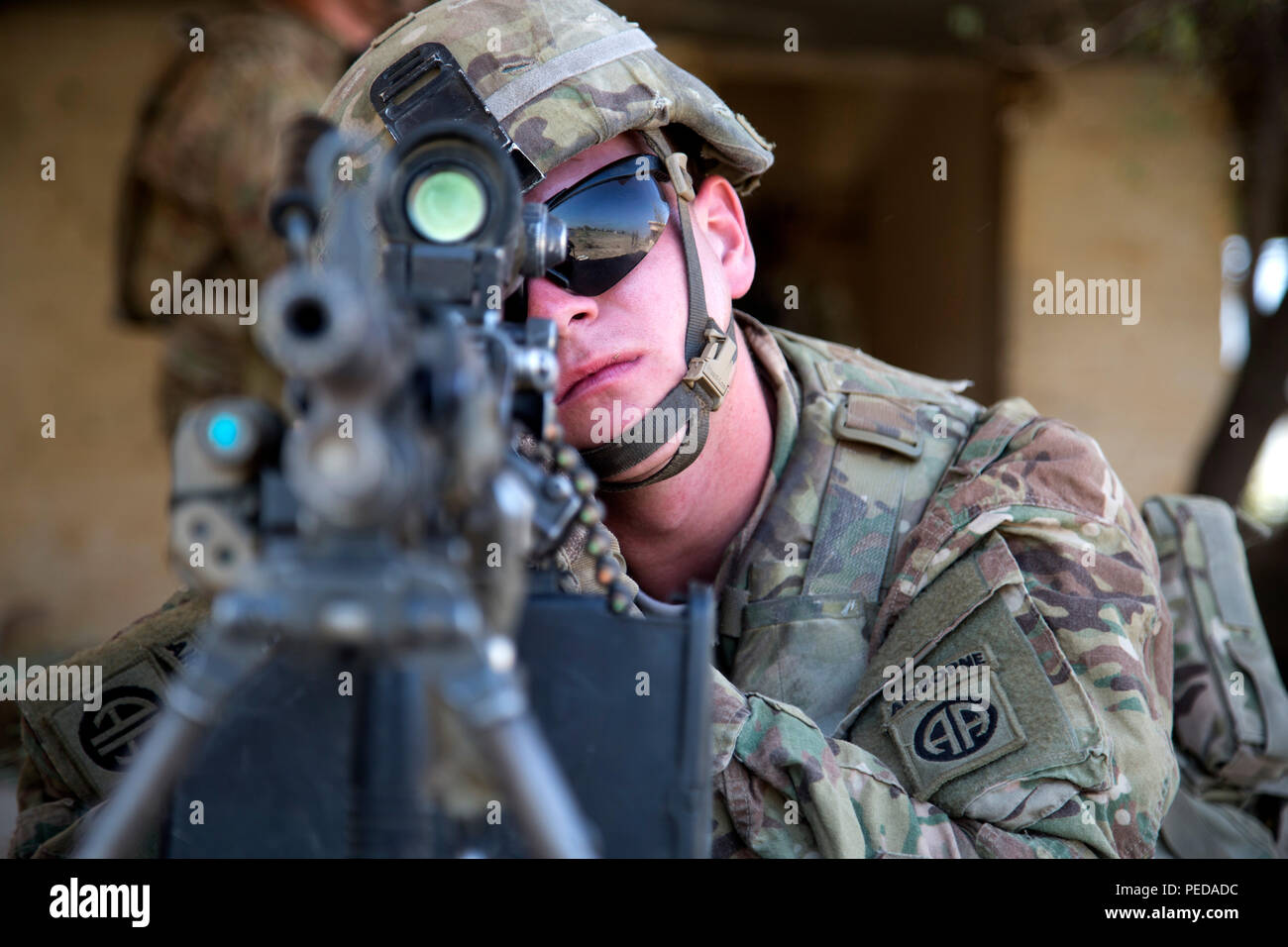 U.S. Army Pfc. Eric Krussier, a paratrooper assigned to Bravo Troop, 5th Squadron, 73rd Cavalry Regiment, 3rd Brigade, 82nd Airborne Division, looks down his sights of his weapon while he pulls security during squad level training at Camp Taji, Iraq, Aug. 3, 2015. Coalition forces routinely practice what they plan to teach Iraqi soldiers prior to each round of instruction. Training at the building partner capacity sites is an integral part of Combined Joint Task Force – Operation Inherent Resolve’s multinational effort to train Iraqi security force personnel to defeat the Islamic State of Iraq Stock Photo