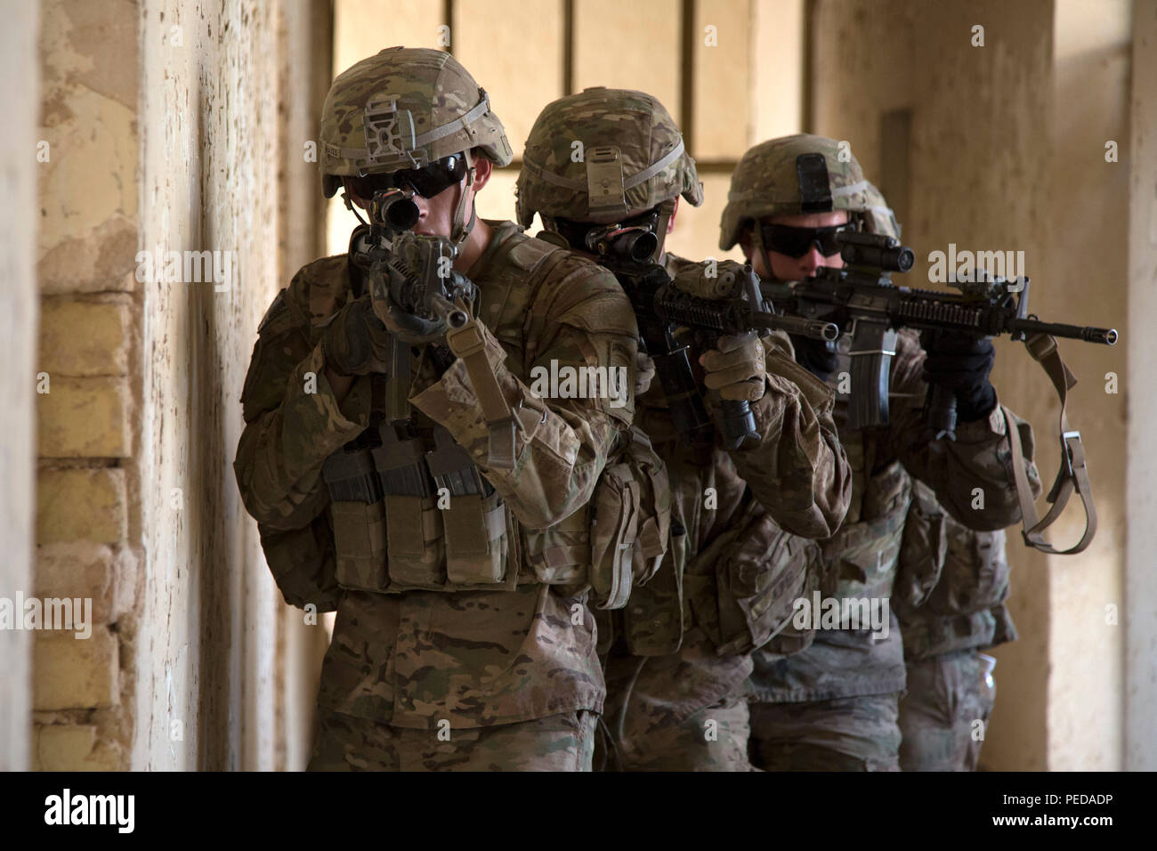 U.S. Army paratroopers assigned to Bravo Troop, 5th Squadron, 73rd Cavalry Regiment, 3rd Brigade, 82nd Airborne Division, maneuver through a hallway as part of squad level training at Camp Taji, Iraq, Aug. 3, 2015. Coalition forces routinely practice what they plan to teach Iraqi soldiers prior to each round of instruction. Training at the building partner capacity sites is an integral part of Combined Joint Task Force – Operation Inherent Resolve’s multinational effort to train Iraqi security force personnel to defeat the Islamic State of Iraq and the Levant. A coalition of regional and inter Stock Photo