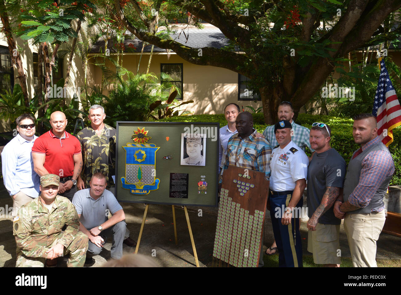 Former Soldiers 1st Battalion, 21st Infantry Regiment, 2nd Stryker Brigade Combat Team, 25th Infantry Division and battle buddies of Cpl. William L. McMillan III, a native of Lexington, Ky., take a photos next to McMillan’s shadow box during a Clinic Dedication Ceremony at the Schofield Barracks Health Center Aug. 6. McMillian, while serving on his first tour of duty, gave his life on June 8, 2008, in Baghdad, Iraq, when his patrol was struck by an improvised explosive device. (U.S. Army photo by Staff Sgt. Carlos Davis, 2nd Stryker Brigade Combat Team Public Affairs/Released) Stock Photo