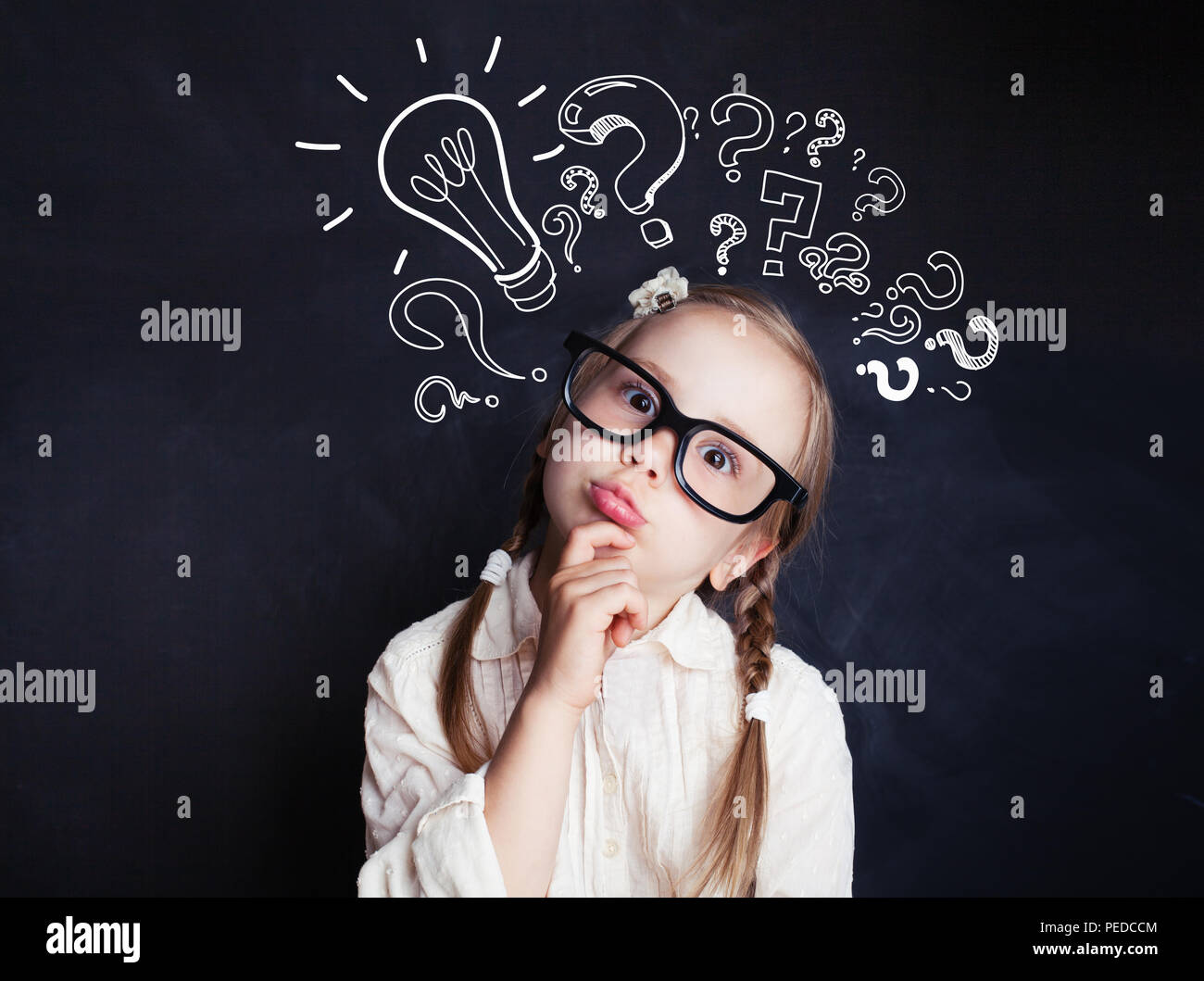 Cute child little girl with chalk lightbulb new idea symbol . Kid ideas and brainstorm Stock Photo