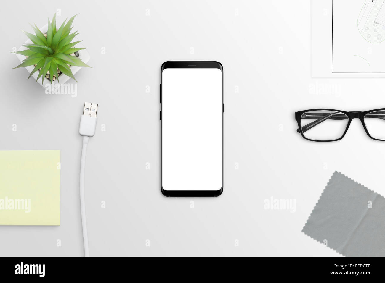 Modern smart phone with round edges on white desk. Isolated screen for mockup. Stock Photo