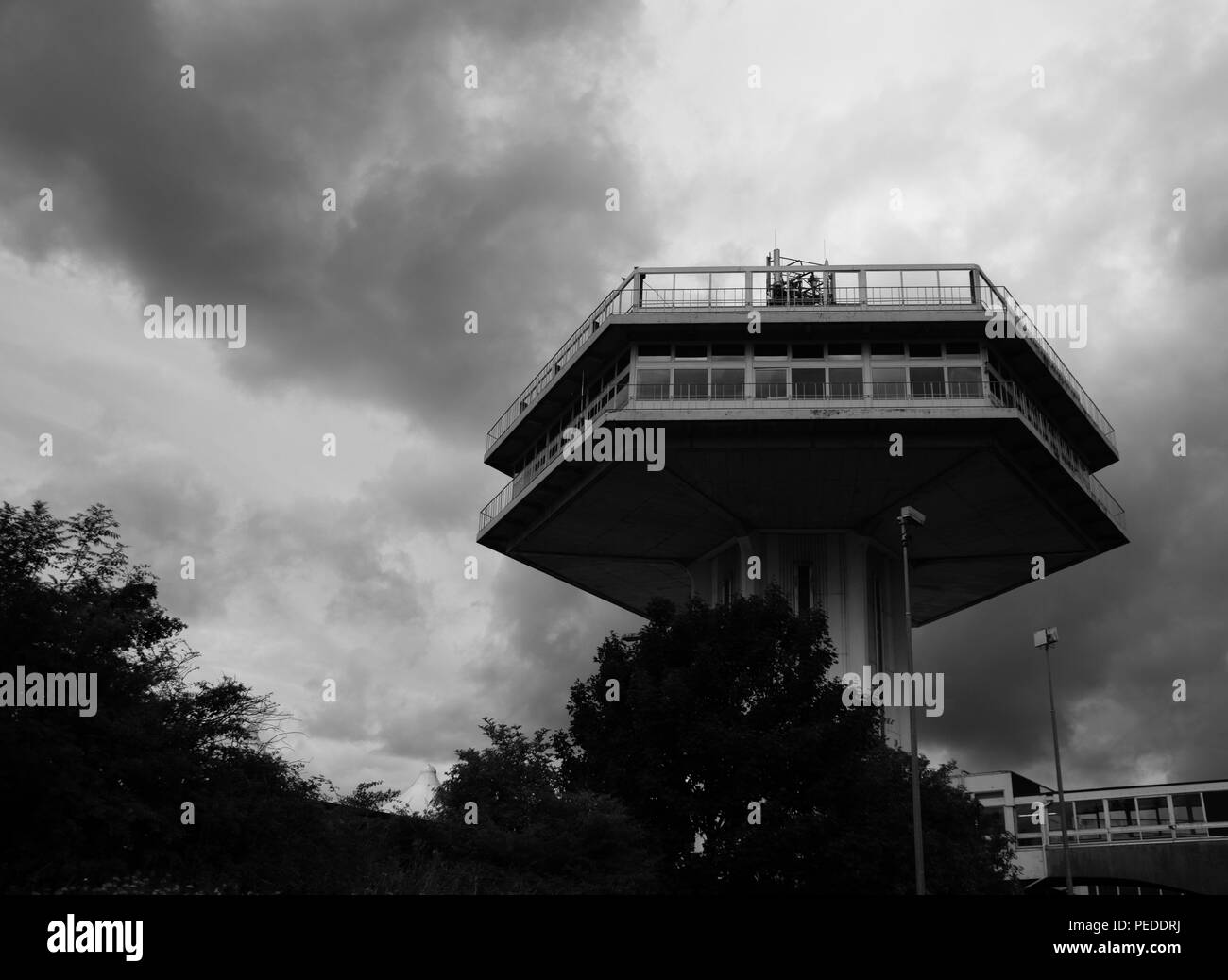 Monochrome image of Dark clouds gathering behind the Penine tower of Lancaster Service Station on the M6 Stock Photo