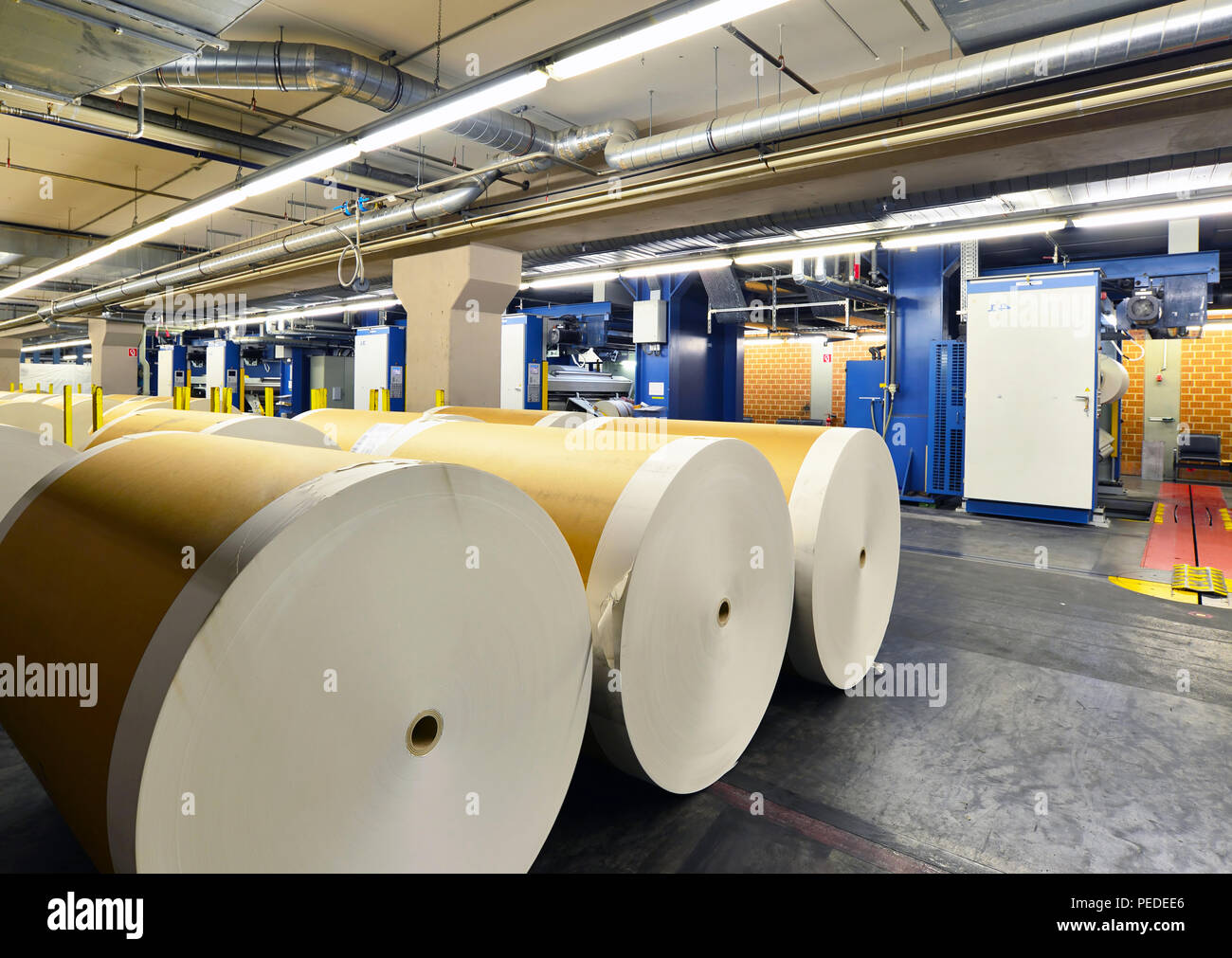 paper rolls and offset printing machines in a large print shop for