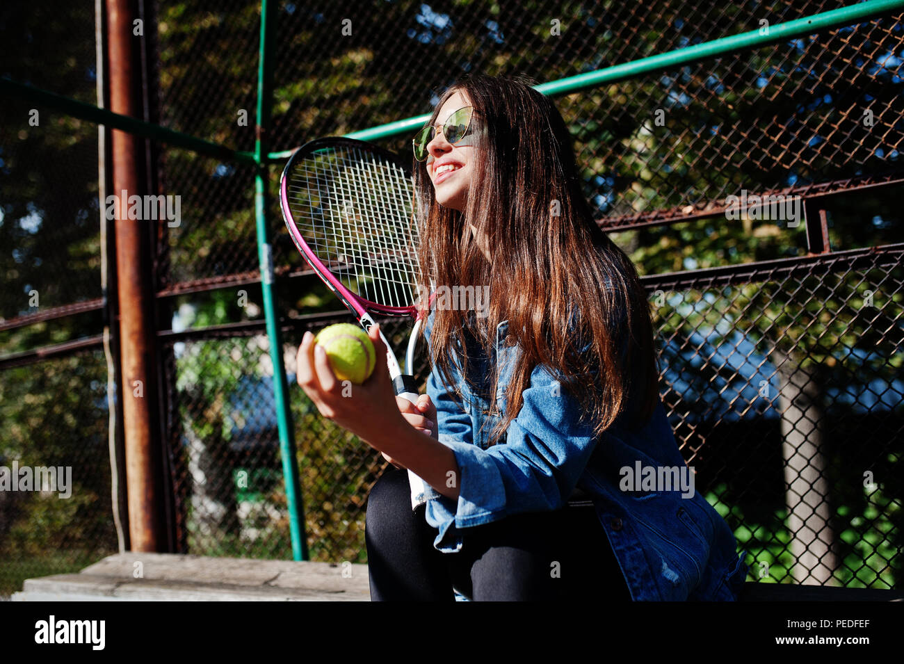 Young sporty girl player with tennis racket on tennis court Stock Photo