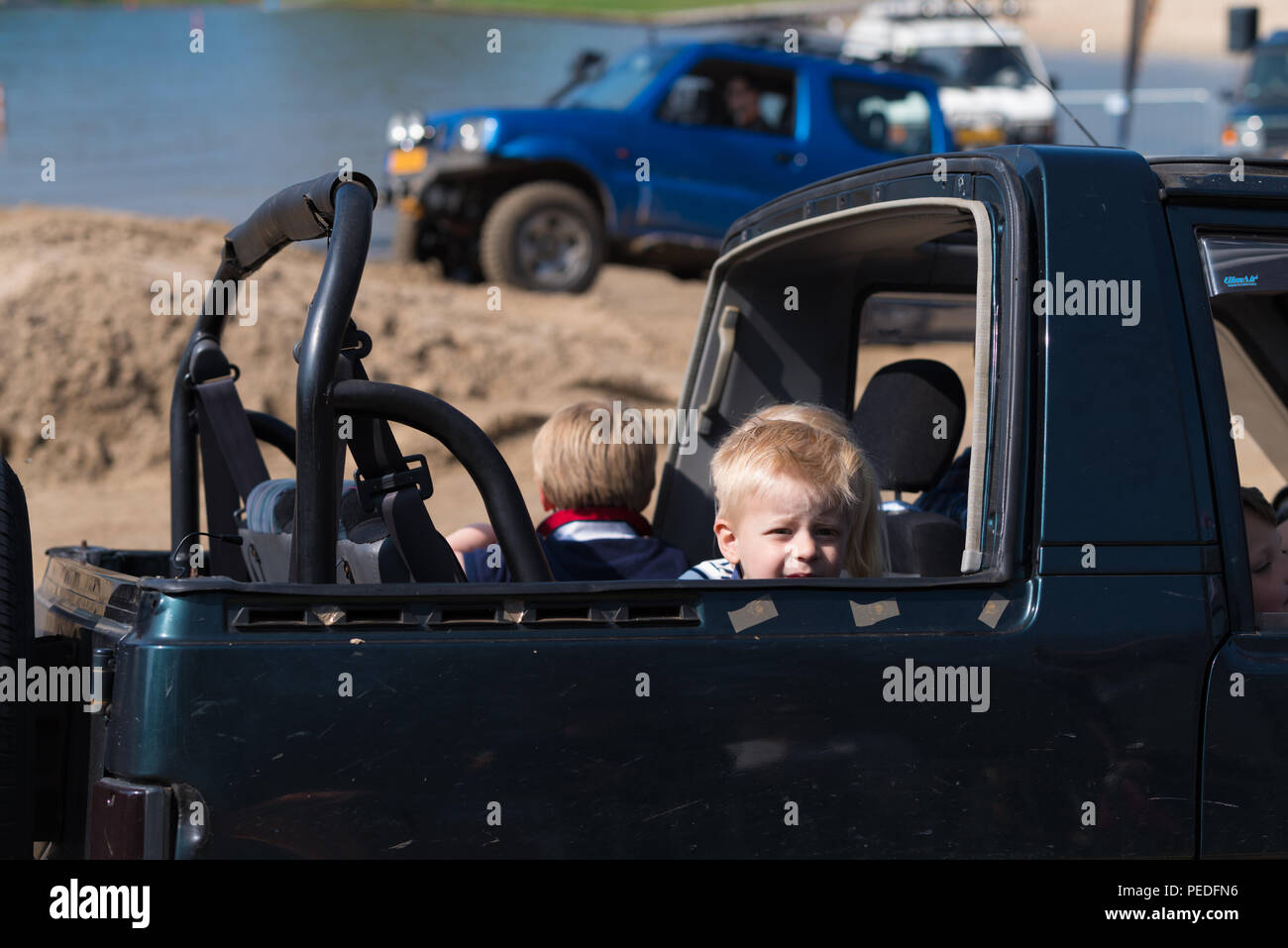 OLDENZAAL NETHERLANDS - APRIL 9, 2017: Unknown kids in an open backseat of an offroad car during an annual event Stock Photo