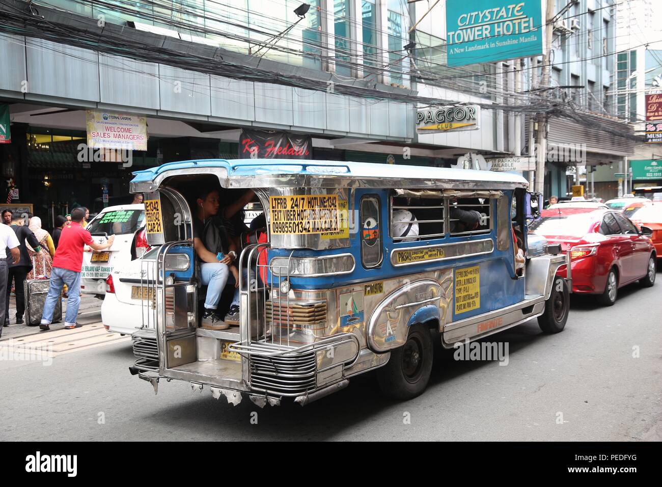 MANILA, PHILIPPINES - NOVEMBER 25, 2017: People ride a jeepney public transportation in heavy traffic in Manila, Philippines. Metro Manila is one of t Stock Photo