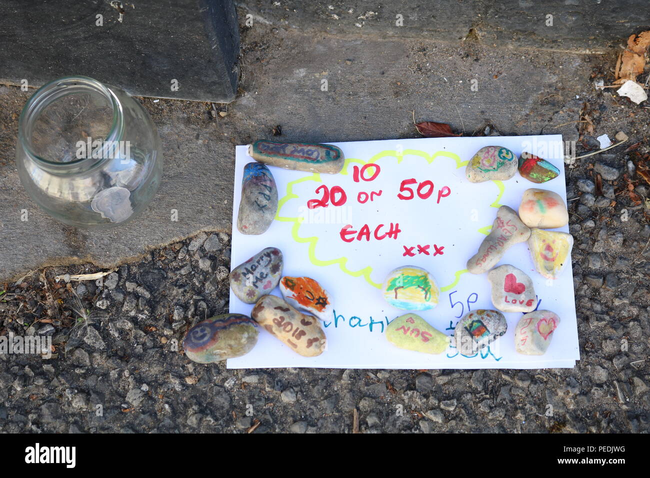 Selling Pebbles Hand written sign by a child to sell decorated pebbles lying on a ...