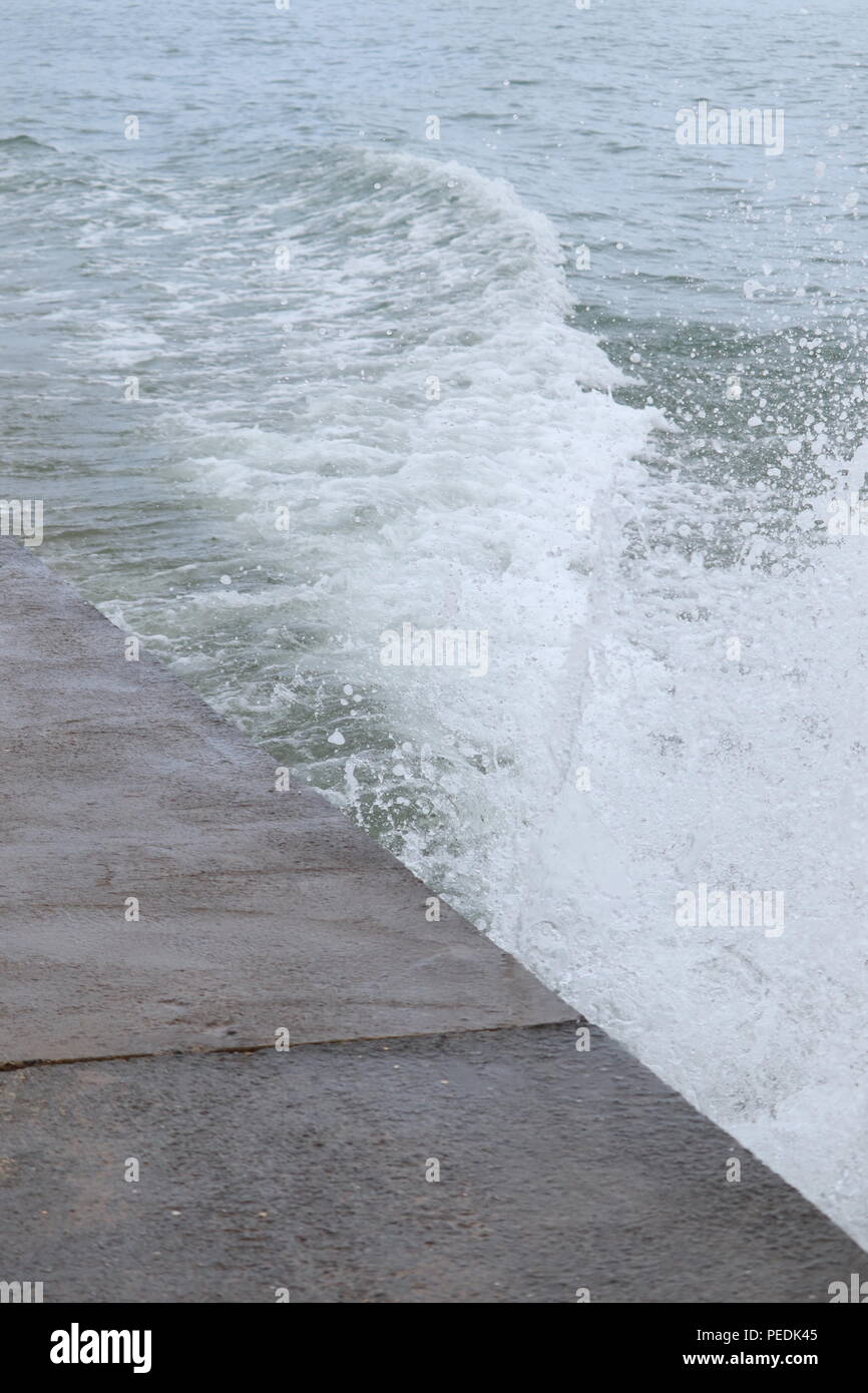 Walcott beach Norwich England sea defence system,wooden groynes holding back the water. Splashing waves Stock Photo