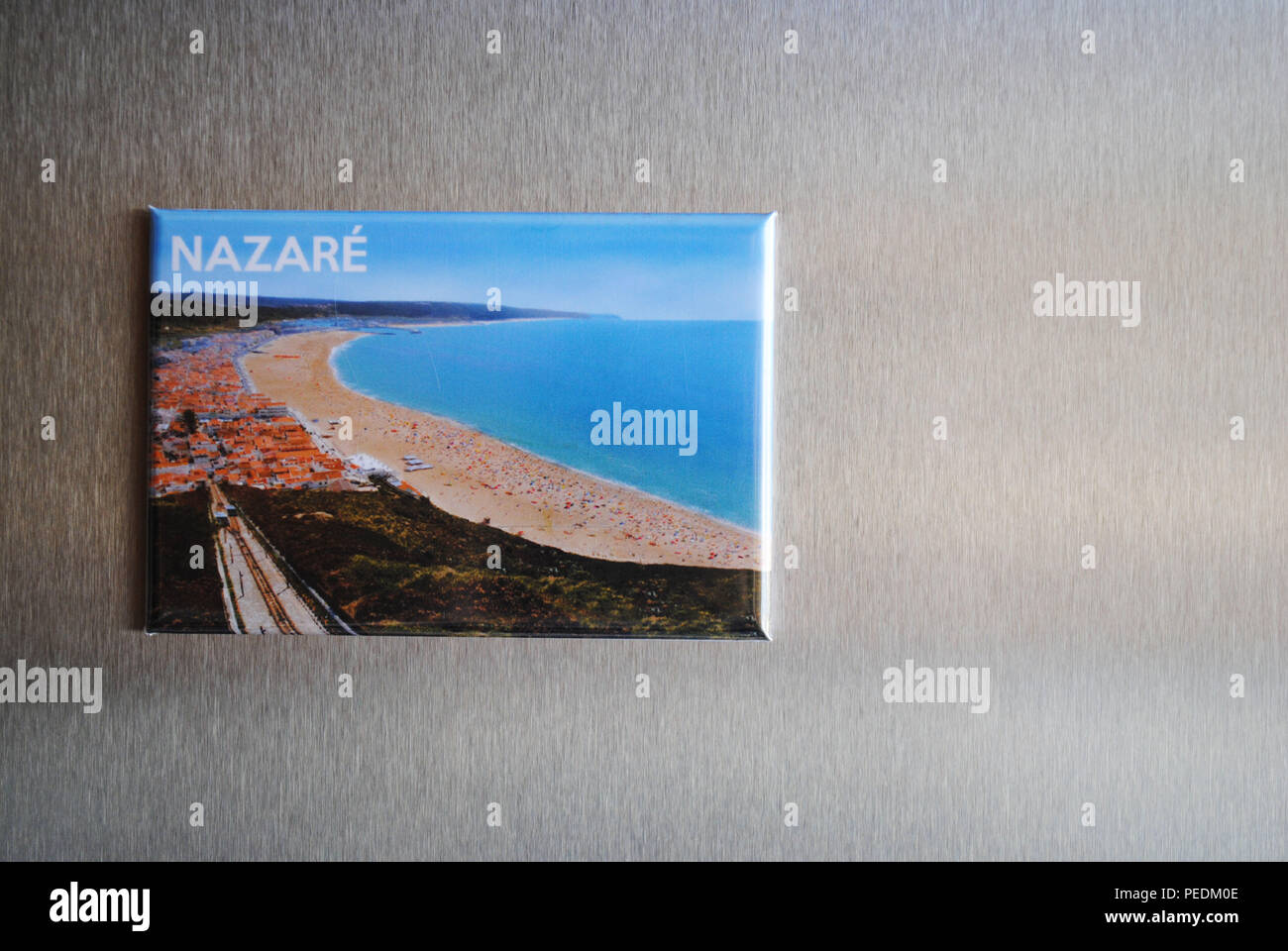 A souvenir fridge magnet showing the long sandy beach of the Portuguese  town of Nazaré on the Atlantic coast. Stock Photo