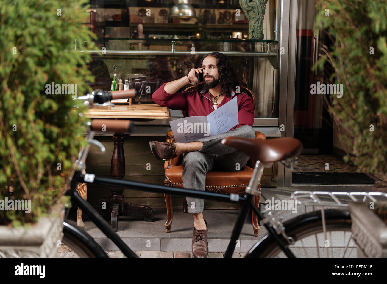 Handsome long haired man making a call Stock Photo - Alamy