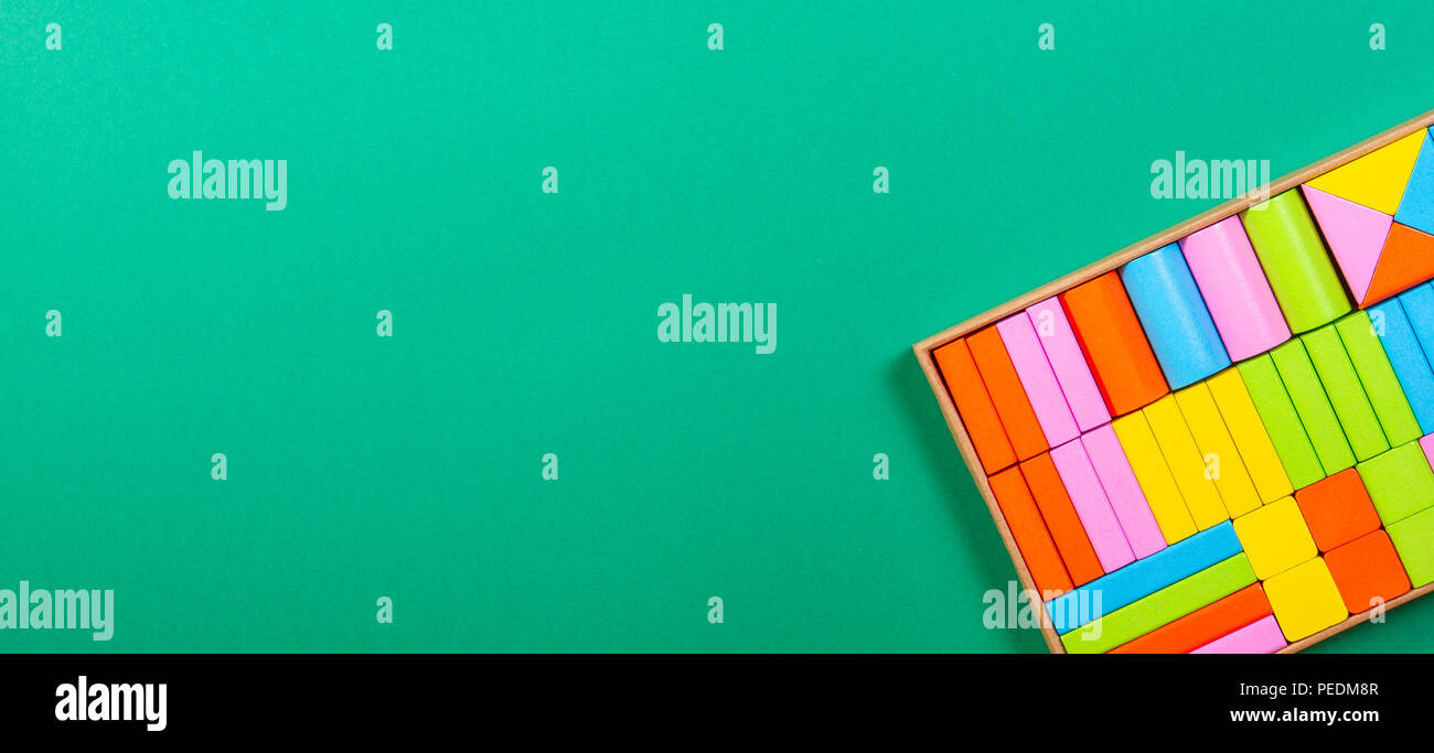 Colorful wooden blocks in the box on green background Stock Photo - Alamy