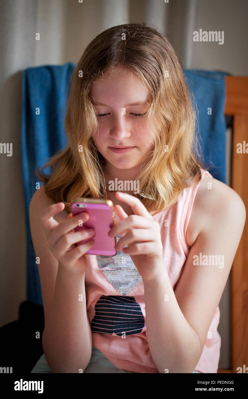 Girl playing on pink iphone Stock Photo Alamy