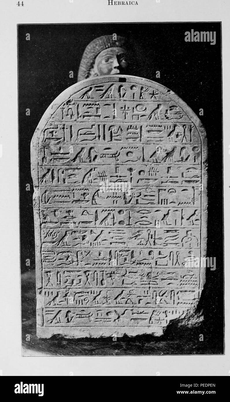 Black and white photograph of an Egyptian statuette holding a tablet with a hymn to the sun written on it in hieroglyphics, published in Philip Schaff's 'The American Journal of Semitic Languages and Literatures', 1895. Courtesy Internet Archive. () Stock Photo
