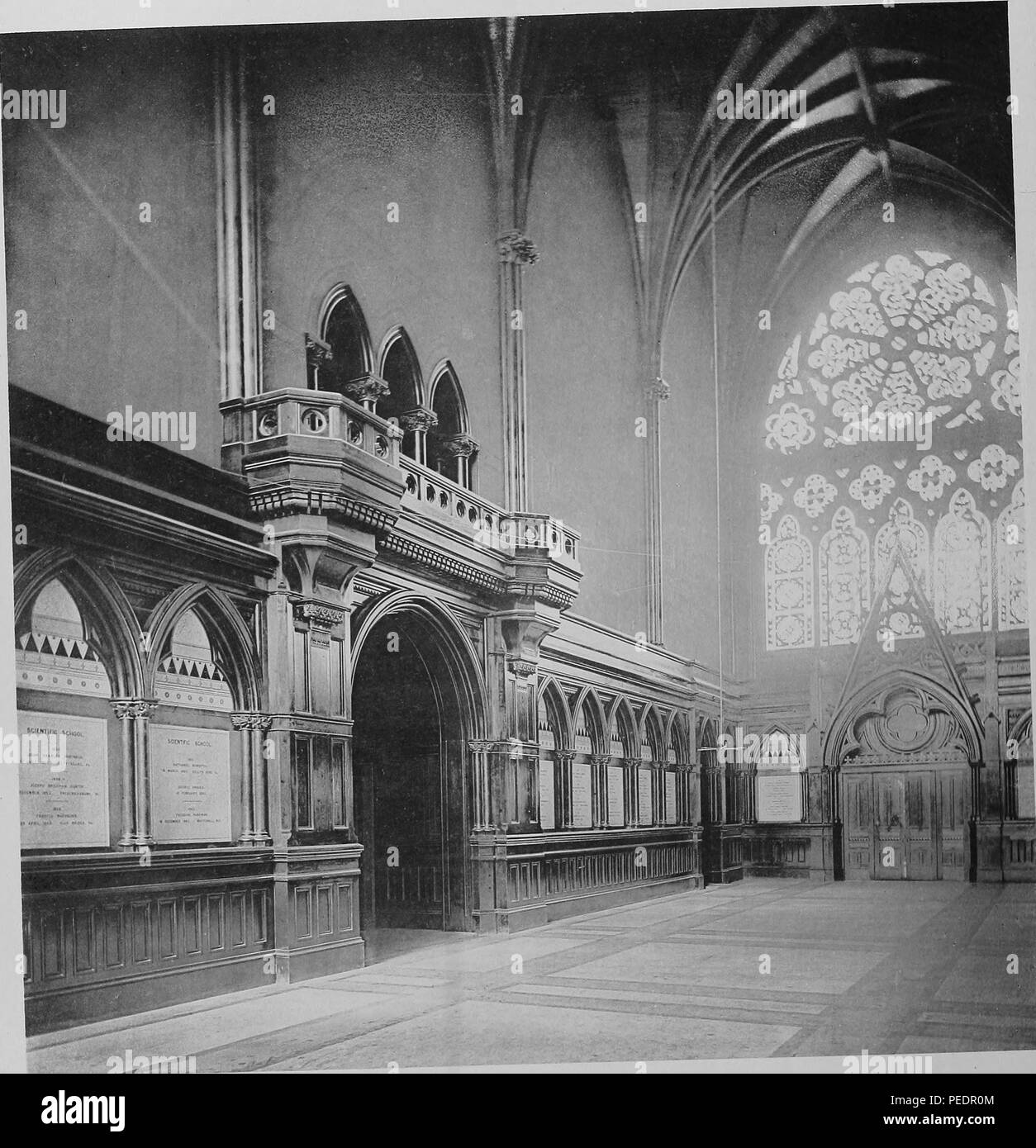 Black and white photograph showing an interior view, looking toward the south door and windows of the Memorial Transept at Memorial Hall, a late 19th-century Gothic revival building built to honor Harvard men who died in the Civil War, located north of Harvard Yard in Cambridge Massachusetts, 1875. Courtesy Internet Archive. () Stock Photo