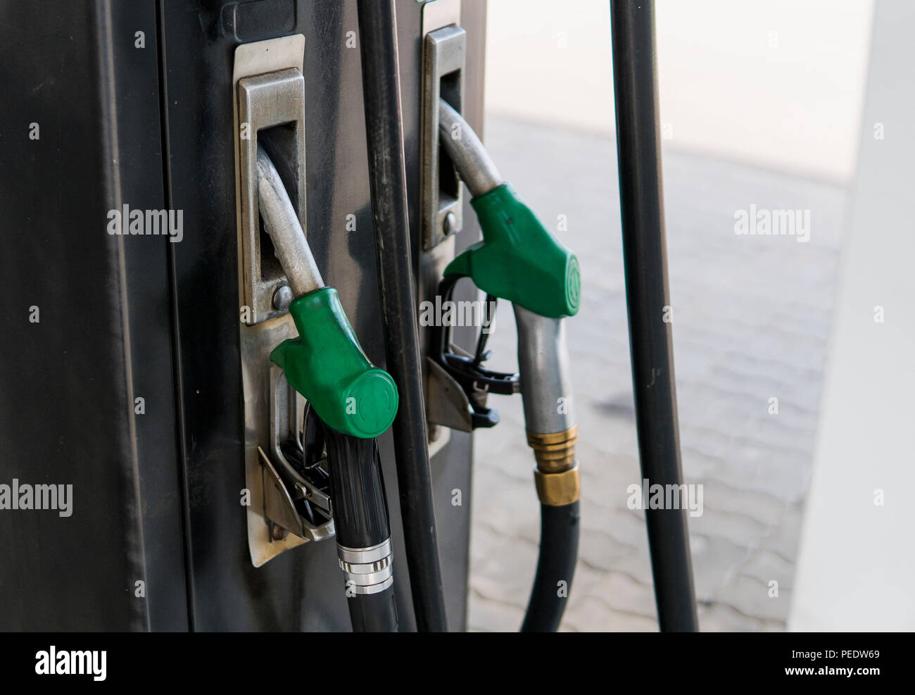 Close up on dirty fuel nozzle in oil dispenser with gasoline and diesel