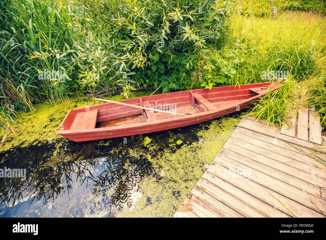 Wooden boat on the river bank at the wooden pier Stock Photo - Alamy