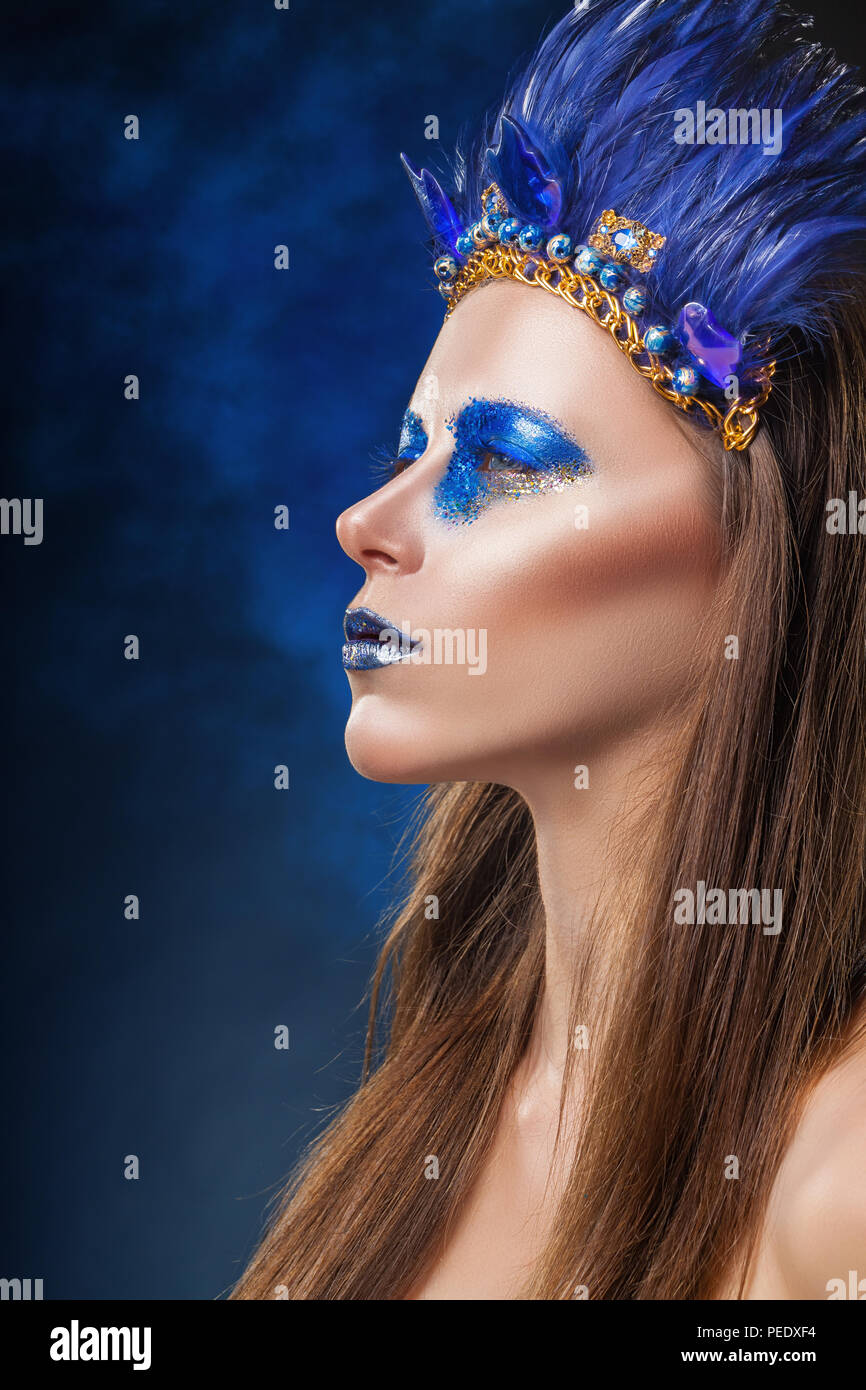 Fashion makeup in the American Indian style. Attractive woman with make-up with bright blue feathers Stock Photo