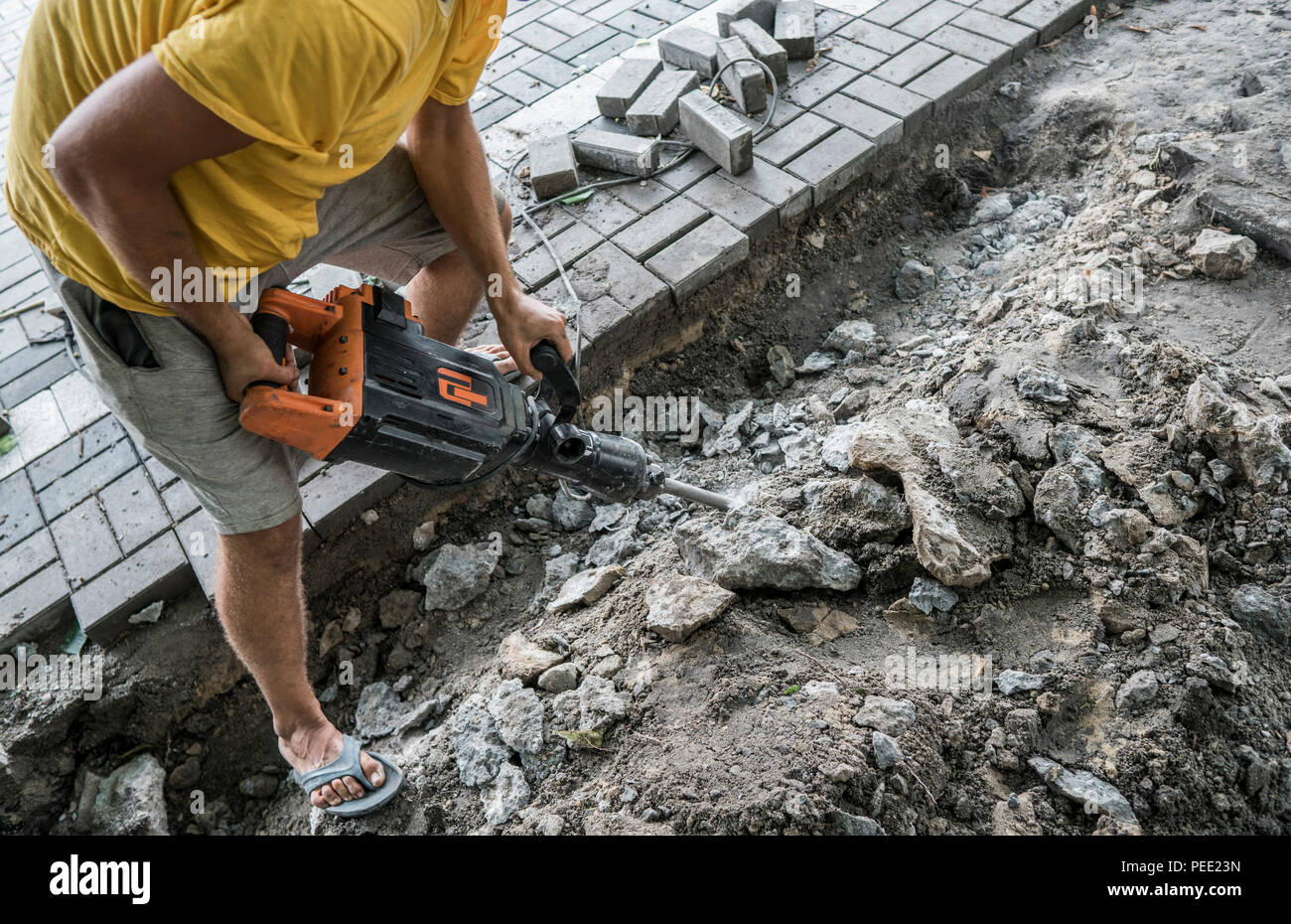 Workers use Electric Concrete Breaker. Male worker repairing driveway surface with jackhammer