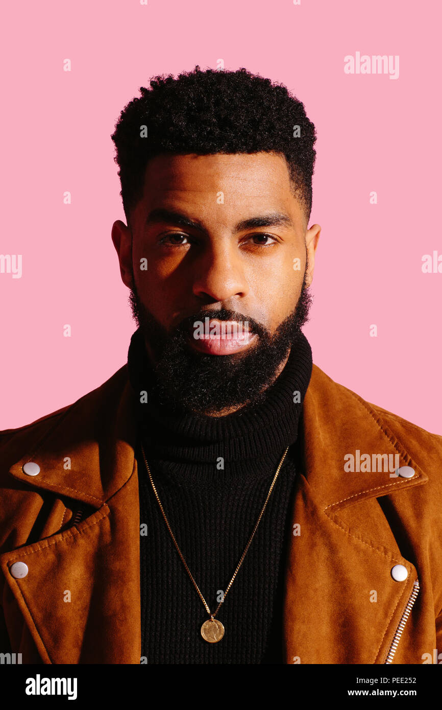 Portrait of a handsome man with beard a isolated on pink studio background Stock Photo